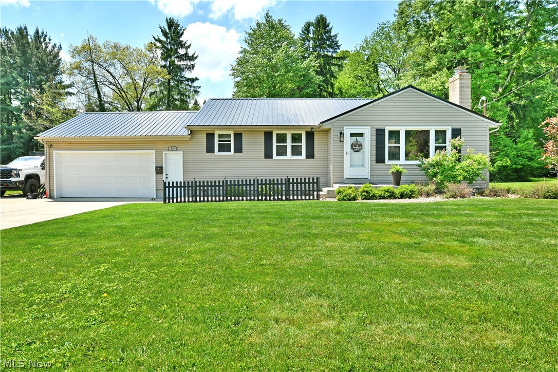Classy, contemporary and packed with charm across two floors of finished living space, this engaging Poland ranch has all the right stuff and more! Picture perfect from the inside out; the home awaits with its bold metal roofing and pleasing, natural colorways that instantly separate it from its peers. The cement driveway leads to a two-car, attached garage while continuing along the side for additional parking for vehicles, watercraft and more. Meanwhile, a sizeable rear patio ties in via sidewalk, creating an easy backyard entertainment venue, all while joining the raised wooden deck. Through the decorative front door, a remarkable living room awaits with its stunning accent wall and brick trimmed fireplace. The large picture window spills sunshine across the hardwood styled flooring while bar top dining looks on. Additional central dining space is located before the must-see kitchen, boasting custom cabinetry, stone countertops and a daring, farmhouse style sink that pairs with the dark stainless appliances. Down the main hall, an illustrious master bedroom steals the show with its instant access to the rear deck. A pair of additional bedrooms include a currently configured home office space, each with ample closet storage. At the end of the hall, an incredible full bath wows with its lavish soaking tub and deep-set, tiled shower with its elegant glass entry door. Downstairs at the basement level, plenty of flex and rec space joins a home gym and wooden bar. Laundry and additional storage complete the floor.