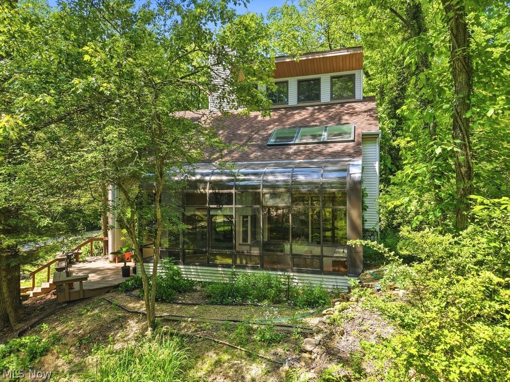 Looking for a great investment opportunity close to Downtown Hudson?  This could be the one! This home is located on a beautiful 1.75-acre lot with a stream running through the front yard. The home is eccentric with a sunken living room with gorgeous fireplace, front solarium room and lots of skylights. Kitchen has been updated with stainless steel appliance, double over and gas range. Some recent updates - Furnace- 2022, 3 skylights in master bedroom replaced - 2025, AC approx.- 10 years old.  Don't miss out on this great place!