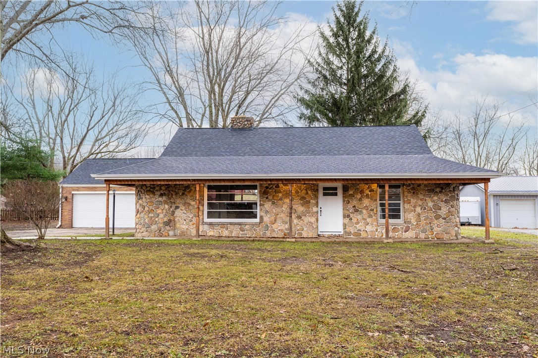Welcome to this beautiful stone bungalow, brimming with charm and nestled on 2 peaceful acres of countryside. A perfect blend of modern updates and timeless cottage character. Step onto the stunning covered front porch, accented with cedar beams, and picture yourself enjoying quiet mornings with coffee. Inside, the inviting great room sets the tone with a wood-burning fireplace surrounded by stone, a beautifully crafted mantle, and a unique curved built-in bookcase that adds both charm and function. The heart of the home is the bright, updated kitchen featuring classic white cabinetry, subway tile backsplash, stainless steel appliances, and generous counter space. Just off the great room, you’ll find two spacious bedrooms and a full bath with a tiled tub/shower combo and a large glass block window. Upstairs, two more cozy bedrooms showcase warm wood paneling, built-in trundle beds, and a convenient half bath. For those who love natural light, the sunroom offers the perfect spot to relax, with a brick accent wall, sliding glass doors to the patio, and access to the attached 2-car garage with a workbench. Outside, your private countryside retreat awaits a patio for gathering with friends and family, and a 30x40 barn with 5 stalls, electricity, and three large fenced-in pens, ideal for animals to graze and roam safely. The partially finished basement adds even more versatility with a large rec room, plenty of storage, and a laundry area. Some recent updates include a new roof, siding, furnace, central air, appliances, kitchen cabinets, bathroom, flooring throughout, and a garage door. Don’t miss the chance to call this charming country retreat your own. Schedule your private showing today!