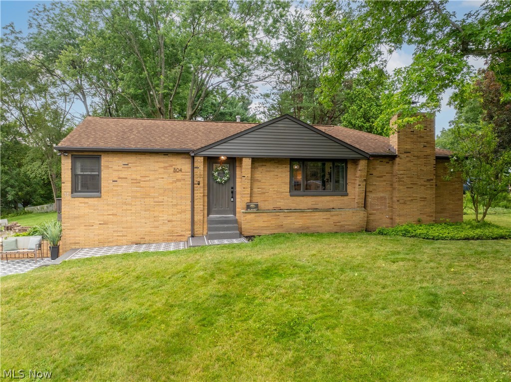 Welcome to this unsuspecting ranch-style home tucked away in North Canton. Completely renovated and move-in ready, this exceptional home offers over 2,000 square feet of thoughtfully designed living space, blending high-end finishes with touches of its original character. Step onto the inviting front porch and into the tranquil great room, where a soft neutral palette, light flooring, and abundant natural light create an airy atmosphere. A sleek fireplace, accented by a rustic wood mantel and an inset TV, creating a seamless look. Tucked behind a vintage pocket door, the private primary suite is a retreat. Moody tones create a calming space, while an expansive built-in wardrobe provides storage. The spa-inspired ensuite features high-end tile, a double vanity with vessel sinks, a modern freestanding tub, and a beautifully tiled walk-in shower, creating the perfect space to unwind. The heart of the home is the breathtaking kitchen. Quartz countertops extend into a full-height backsplash, complementing crisp white cabinetry with elegant gold hardware and stainless steel appliances. A large island with a warm wood accent offers additional seating, while the adjoining dining area is surrounded by a wall of windows overlooking the lush backyard and sliding glass doors to the deck. The spacious yard is complete with a deck, a patio, fire pit, and plenty of green space for outdoor games, gatherings, or simply relaxing. Down the hall, you'll find two generously sized bedrooms and a full bath featuring timeless black-and-white tile flooring with charming brick accents. The finished lower level expands the home's living space with a large recreation room, a convenient half bath, and a charming laundry room. Just off the garage entrance, a mini mudroom with a built-in drop zone adds everyday convenience. Beautifully renovated from top to bottom, this luxurious home is ready for its next owner. Schedule your private showing today!