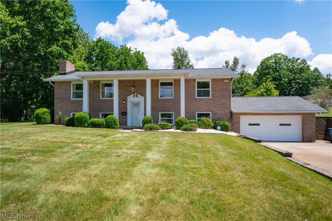 Solid, spacious, and well cared for, this all-brick bi-level offers great curb appeal, a functional layout, and a fantastic lot in Green. A covered front porch welcomes you inside, where split stairs lead up to the main living area featuring warm wood stair details and an easy flow throughout. The spacious living room opens to the dining area, where sliding doors lead to the back brick paver patio for convenient indoor-outdoor living. The eat-in kitchen offers plenty of wood cabinetry, a newer sink with reverse osmosis and an additional slider to the patio, making it easy to enjoy meals inside or out. Down the hall are three comfortable bedrooms, including a primary bedroom with a large closet and direct access to the shared full bathroom. The main bath features a dual sink vanity, soaking tub, separate shower, and linen closet. The finished lower level adds even more living space with a generous family room, wood-burning fireplace, built-in bookcases, bar area, and large walk-in closet. A second full bathroom with dual sink vanity and standing shower adds convenience, along with an additional bedroom featuring two closets. The unfinished utility room provides laundry space, storage, mechanicals, water softener, and whole-house filter. Outside, enjoy the big backyard, brick paver patio, storage shed, huge driveway with extra parking, attached 2-car garage, and a natural gas Generac generator for peace of mind. A solid home with space, storage, and so much potential!