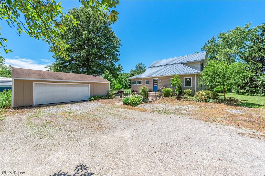 Tucked away on 4 picturesque acres in desirable Brighton Township, just outside the charming village of Wellington, this farmhouse offers room to roam, space to garden, and a lifestyle that's becoming harder to find. Surrounded by open green space, mature shade trees, established gardens, and scenic countryside views, the perfect place to slow down and enjoy every season. Thoughtfully updated while maintaining its farmhouse charm, featuring an updated kitchen with white shaker cabinetry, granite countertops, ample storage, and a built-in bench. The spacious dining room and comfortable living areas are filled with natural light and provide plenty of room for gathering with family and friends. Designed for convenient first-floor living, the home offers two bedrooms on the main level, a spacious primary suite with an updated in-suite bath featuring a Jacuzzi tub and separate shower. A second updated full bath and first-floor laundry off the kitchen add convenience. Upstairs, you'll find a third bedroom along with a bonus room that makes an ideal home office, hobby room, craft room, walk-in closet, or flexible space. Outside, the property truly shines. Garden enthusiasts will appreciate the established garden spaces, apple and pear trees, rich soil, and room to expand their vision. The sprawling lawn and mature trees create the perfect backdrop for outdoor entertaining, hobby farming, raising chickens, or simply enjoying nature. Spend your mornings sipping coffee beneath the shade trees and your evenings watching spectacular sunsets. A large outbuilding provides excellent storage, workshop space, or room for equipment and recreational vehicles. Plus central air, forced-air heating, a detached 2+ car garage, and a basement with walk-out access. Believed to date back to the late 1800s, this charming farmhouse blends historic character with modern comfort. Dreaming of a property where you can garden, grow, create, and enjoy a little more room to breathe - this is it!