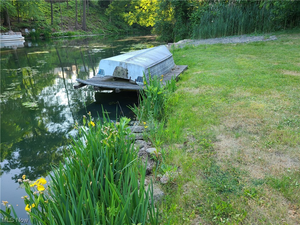 132 SpruceDr NW N. Canton OH 44720 is a stand-alone Fishing Lot in the highly sought after Willowdale Lake Country Club Community with its own dock on leased land. This is an unbuildable lot and is specifically what is commonly known as a Fishing Lot. The boat is negotiable too. This land could be added to the 2 lots next door with the newer home to be able to add on to the home or garage with approval by the Willowdale Board. This is an awesome opportunity for the Buyer of the home to add more land or for a separate Buyer to have a boat dock and fish whenever they wish. There are lease fees and all Buyers must be approved by the Willowdale Board. Willowdale Country Club, Inc. Lease Fee $426.25 per half on Fishing lot. Lessee is responsible for maintaining their own mowing and dock upkeep. There is a gravel base from the pull-off parking drive area between the road and the horizontal wood pole.