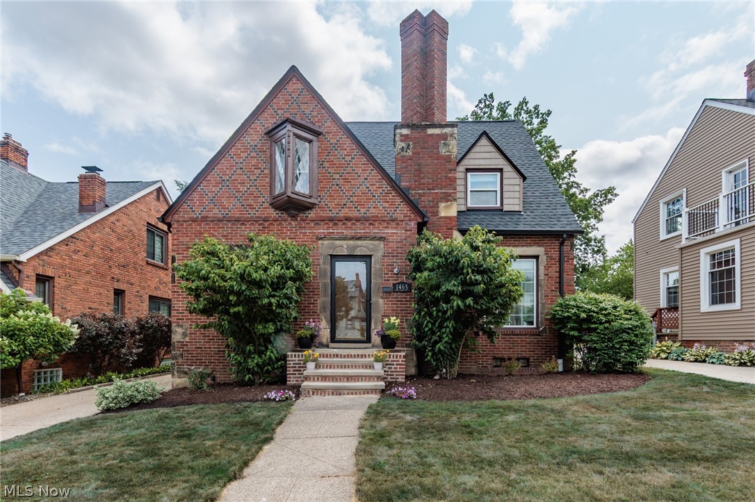 Welcome home to this charming brick Storybook Tudor, where intricate architectural details create exceptional curb appeal. Head inside to a spacious living room featuring original hardwood floors and a classic fireplace. An arched opening leads to the formal dining room, complete with built-in leaded glass china cabinets that add timeless character. Just off the dining room, through an eight-panel wood door, is the fully updated kitchen, featuring white cabinetry, stone countertops, and stainless steel appliances. Also on the main level are a guest bedroom, a powder room, and a bright, airy sunroom overlooking the backyard. A few steps up from the main landing, you'll find a private office, perfect for working from home. The second floor offers three spacious bedrooms and a full bath that blends modern updates with original charm, featuring an updated vanity alongside beautifully preserved tilework. The lower level provides even more living space with a versatile bonus room, a recreation room with a bar, a second powder room, a laundry area, and plenty of storage. Outside, the thoughtfully landscaped backyard surrounds a beautiful paver patio and offers ample green space for relaxing or entertaining. Conveniently located just minutes from shopping, dining, entertainment, parks, and easy highway access, this home perfectly combines timeless character with modern updates.
