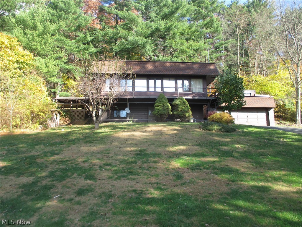 Lake front-3 bedroom, 2 bath cottage at Tappan Lake.  Skylight in the kitchen which includes the appliances.  First floor family room has separate heating and window air includes.  The family room includes a kitchenette, 2 skylights and sliding glass doors to the 11 X 22 covered deck.  First floor full bath with skylights.  Finished walk out lower level includes a rec room.  Vinyl thermo replacement windows.  2+ car attached garage.  Lots of outdoor entertainment areas.  12 X 8 wooden storage building with electric is a potential bunk house.  8 X 8 metal storage shed.  One of the best lake views of any home on the market.  30'+/- treated wood dock.  MWCD annual lease fee of $2,416.00 for 2016.  The taxes reflect the seller receiving a homestead credit of $363.50 annually.  Excellent opportunity for weekend get a way or year round living.