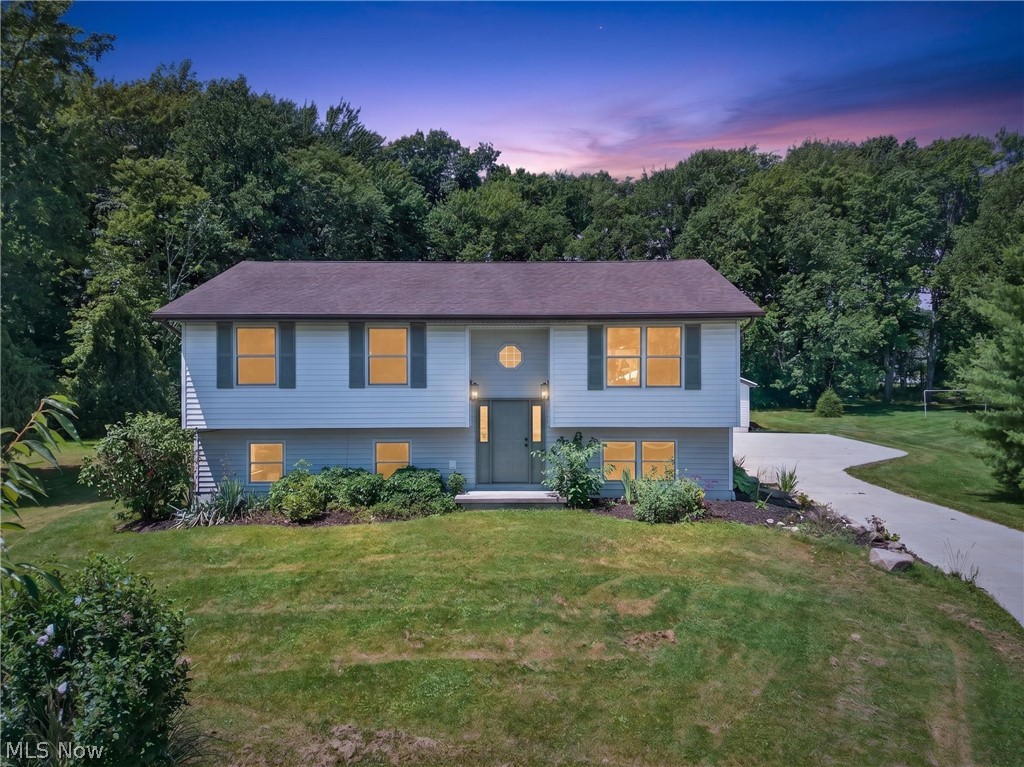 Welcome to this beautifully updated split-level home in Kirtland, offering a premium amount of space and endless flexibility! With 5 spacious bedrooms, this layout provides incredible opportunity for a dedicated home office, playrooms, or guest suites. The main level boasts a bright, open-concept kitchen, dining, and living area that is perfect for entertaining, complete with a large island and seamless access to a massive, two-level partially covered back deck. Down the hall, three convenient bedrooms include a primary bedroom with a pocket door for direct access to the main bath, which features classic white subway tile and a freestanding soaking tub. Downstairs, the finished lower level expands your living space with a large recreation room, a second updated full bath, an additional sunlit bedroom, flex room, and a practical mudroom/utility room. Outside, enjoy a large, naturally shaded yard and a detached 2-car garage with an expansive concrete pad. Move-in ready and loaded with updates—schedule your tour today!