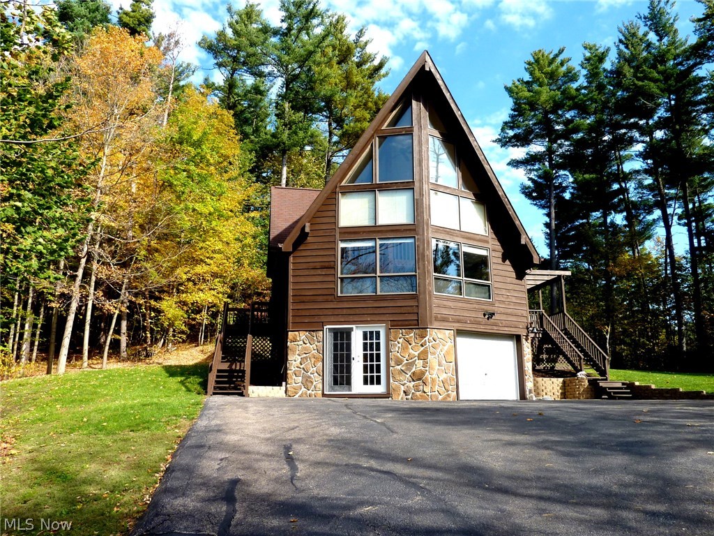 Rare A-Frame construction on almost 8 acres of pristine land in Montville Twp offers incredible wooded and rustic views from the wall of living room windows.  Structurally certified (adequate for all four Ohio Legal Load trucks) bridge crosses the West Branch of the Rocky River and massive front yard (great spot for parties), and winds up to the home site with cleared yard and fire pit area.  Once inside, stay warm with a professionally installed wood stove with stone chimney to the rafters (as well as matching stone exterior stacked to the chimney cap).  Remodeled kitchen features tons of cabinet space and stylish granite countertops.  Two first floor bedrooms are flanked by a full bathroom.  Second floor master suite features a sitting room, additional bedroom/nursery/office that leads to master bathroom and bedroom with private views to the back.  Finished room in the walkout basement great for watching ballgames and has a half bath.  Wildlife everywhere, this home and land provides