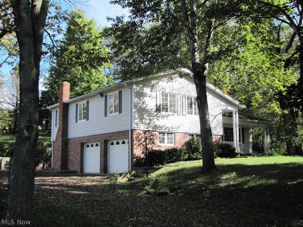 Very well built  custom split level sitting on a wooded knoll in a charming rural setting. Easy access to SR 21 to west and S93 to east.The home has a great layout with large living room, foyer, dining room and kitchen on main level, three super large bedrooms on upper level, a beautiful paneled family room with full wood burning fireplace and double doors to outside patio on lower level.  All the carpeting on upper two levels is new and its main rooms and bedrooms have been freshly painted. New lighting fixtures in most areas. Pella windows. Newer roof and brand-new hot water tank, efficient baseboard heating.