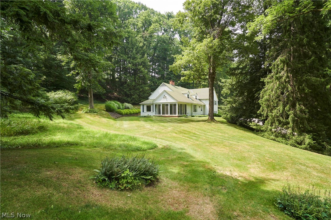 Escape to this unique 8+ acre private nature retreat in the heart of Bath Township (and part of the Yellow Creek Corridor). This extraordinary property features two separate near-century homes. While both are set back considerably from the road, the cottage-style home—situated in the forefront and one of the first built on the street—is a charming 2-bedroom raised ranch at 2803 Yellow Creek, affectionately known as "The Tree House”. The second home is nestled at the back and top of the valley and is a grand, spacious 4-bedroom split-level at 2801 Yellow Creek—making it ideal for multigenerational living, a home/office compound, or as an income-producing asset. This rolling landscape ensures excellent privacy and separation between the homes while sharing a driveway. In a sought-after neighborhood, the grandfathered status allowing two homes on one property is rare to the area, offering a legacy estate like no other. Towering Oak, Spruce, Buckeye, Walnut, and Chestnut trees create a breathtaking natural canopy, while lush foliage and frequent wildlife visits make every season feel like an escape. In the raised ranch, expansive picture windows frame the woods, creating the perfect setting to relax beside the wood-burning fireplace on a snowy winter day. The inviting sunroom opens to a newly refurbished deck. On this rare estate-sized property, additional features include a barn with electricity and two whole-home standby generators. Tucked away in a serene setting but minutes from I-77, it is conveniently located near local shopping and neighborhood favorite dining spots like Lannings and Gasoline Alley. Most notably, the property is located only 2 miles from the nationally recognized Cuyahoga Valley National Park, famous for its lush forests, historic locks, and direct access to the 90+ mile Towpath Trail. All of the unique attributes accompanying these two homes make it a truly exceptional opportunity to own one of the area's most distinctive properties.
