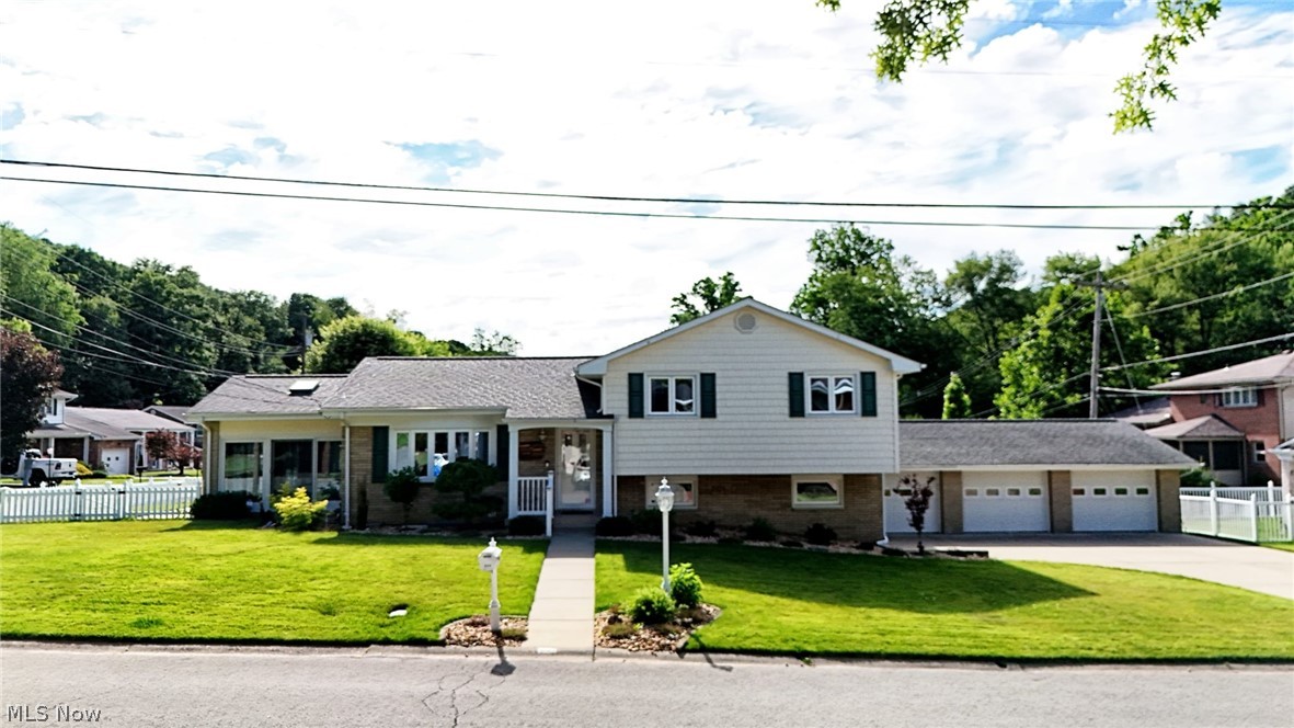 Welcome to 224 Country Club Blvd in Weirton, WV! This home is absolute perfection from the moment you enter into the spacious, bright living room leading to the equipped custom kitchen and dining area with built in cabinetry. Just off the dining area is the fantastic 4 season room with a vaulted ceiling where you will be sure to spend most of your time UNLESS you can't get yourself out of the heated 5 CAR GARAGE space that offers so much room for vehicles, a workshop or your favorite hobby. Just a few steps away the upper level offers 3 nicely sized bedrooms with newer carpeting and updated full bath. The lower level features a large finished rec room and utility area with laundry and second bath. The striking curb appeal of the home situated on a corner lot is undeniable with beautiful landscaping, vinyl fenced space, a retractable Sunsetter awning over a patio area, an inground watering system for the yard and an attached storage room. So many amenities and upgrades to the true gem of a find. Don't wait to call before this one gets away.