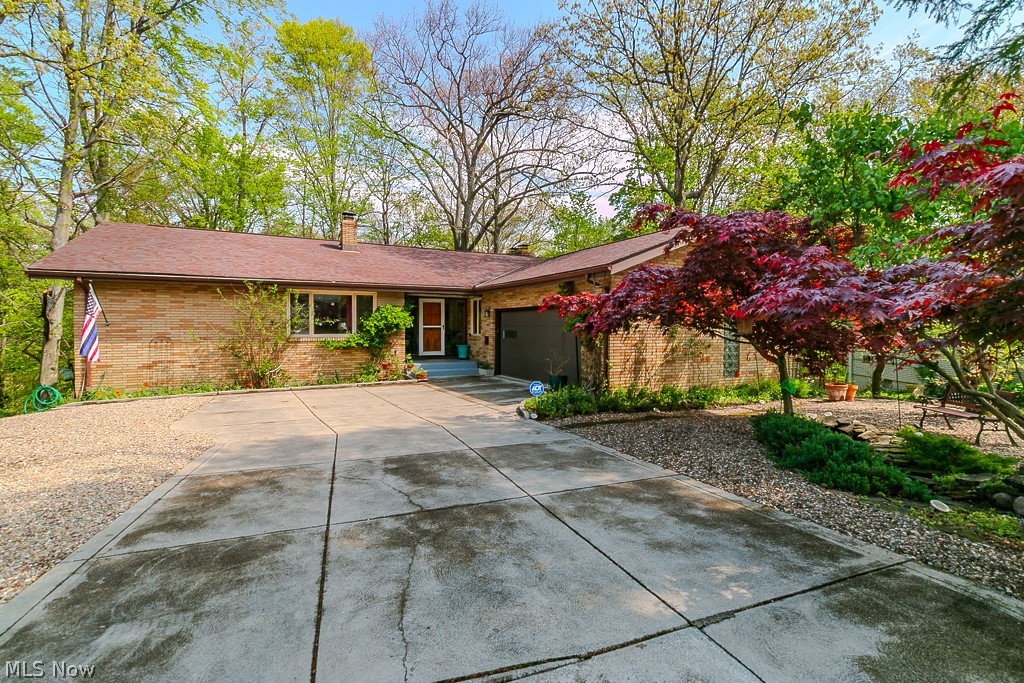 Experience Serene Luxury in this Sprawling all Brick Ranch in Seven Hills.  Boasting of three bedrooms, three full bathrooms and Floor-to-ceiling windows that frame breathtaking valley views.  Each season is a treat!  The autumn foliage is amazing. Even in the winter, you can see the Cleveland skyline.  Enjoy your morning coffee on the balcony while taking in this stunning panorama. Hummingbirds could entertain you for hours. Every corner of this home invites you to unwind. Hardwood floors are throughout the main living area.  Many updates include the remodeled kitchen with newer appliances and a ceramic tile floor. See supplements for a complete list. There is also a formal dining room. Only the second owners, you'll appreciate how everything is tastefully decorated and meticulously maintained. Most of the interior was freshly painted.  The walkout basement features a fireplace and offers even more space and versatility, perfect for entertaining or relaxing.  The basement also has a sectioned-off enclosed area with a large workshop, an enclosed pantry and plenty of storage racks.  You'll appreciate the spacious 2 car garage with newer garage door (2024) and ample shelving for storage.!   Tucked away on a cul-de-sac, it is surrounded by beautiful landscaping, a rock garden and nature. Just a short walk to the park !  The dramatic views from every window will amaze you.  It's like living in your year-round vacation home. Don't miss this one-of-a-kind gem!!