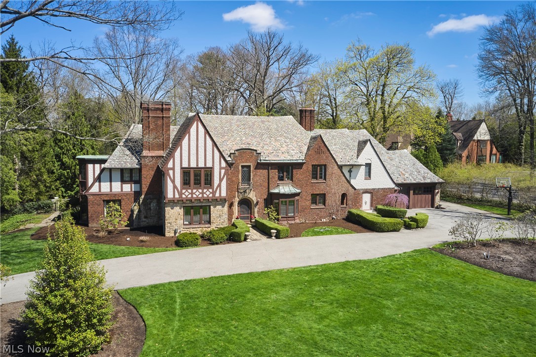The perfect package with exceptional indoor and outdoor living. This remarkable Fairlawn Heights estate on 2.5 acres, rich in craftsmanship and character, has been thoughtfully and luxuriously updated. Original details shine in the formal living room with a linenfold-paneled fireplace, while a screened porch opening to the terrace, a private office overlooking the front grounds, and a welcoming foyer complete this portion of the home.  Designed for both everyday living and effortless entertaining, the open-concept kitchen suite featuring dining, tasting, and conservatory (cocktail) spaces, a full bar, and a secondary prep (“messy”) kitchen, flows seamlessly into the vaulted Great room with beamed ceilings, built-ins, and French doors to the outdoor living areas. Top-of-the-line appliances, including a full-size wine refrigerator, and a direct connection to the family room with fireplace and wet bar, define the true heart of the home. A mudroom with half bath leads to the three-car attached garage.  Upstairs, four spacious bedrooms and three full baths include a gracious owner’s suite with sitting area and a beautifully updated bath featuring a soaking tub and oversized shower. The expansive primary closet offers true luxury, complete with a full-size washer and dryer.  The finished lower level includes a striking wine cellar with capacity for 1,169 bottles, an updated half bath, recreation room with fireplace, workout room, additional laundry, and abundant storage. The pool house (guest cottage, approx. 900 SF) features a bedroom, full bath, kitchen, living room with fireplace, and French doors opening to the pool.  The grounds rival the finest historic gardens, with winding paths, terraces, a labyrinth, and a secluded pool and pool house, all enhanced by gorgeous landscaping and landscape lighting.  Private, polished, and designed to live as beautifully as it entertains.