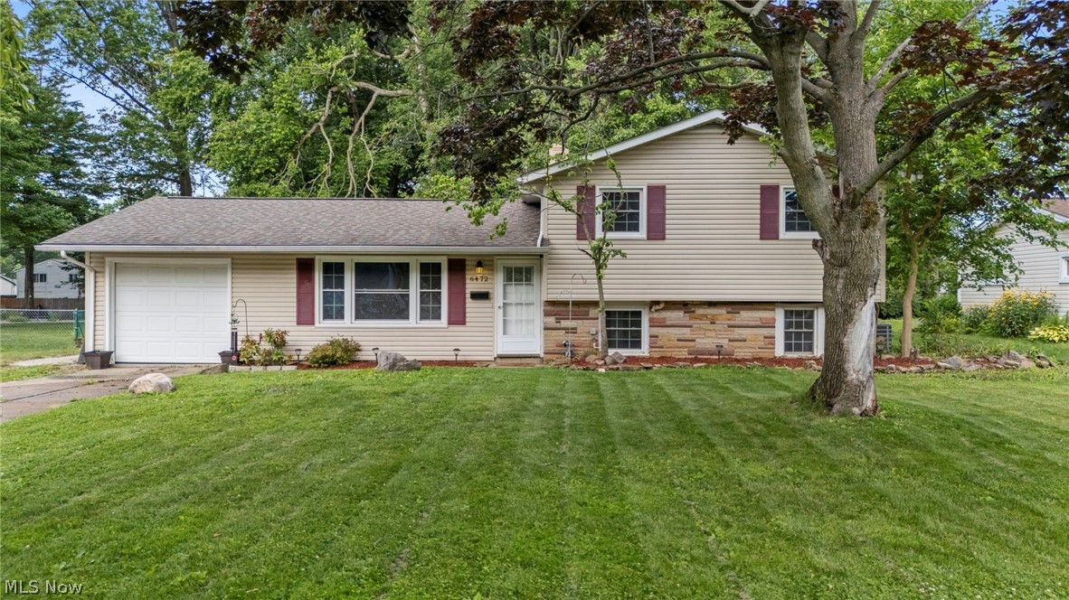 Welcome to 6472 Southgrove Road! Tucked away on a quiet street, this spacious three-bedroom split-level home offers the perfect blend of comfort, style, and privacy. Surrounded by mature trees, the fully fenced backyard creates your own peaceful oasis to relax and unwind. Step inside to a bright and inviting living room filled with natural light, creating a warm and welcoming atmosphere. The beautifully updated kitchen features crisp white cabinetry, light granite countertops, a stylish tile backsplash, and stainless steel appliances—all included. A sliding glass door leads directly to the back patio, making indoor and outdoor entertaining effortless. Just a few steps down, the inviting family room offers the perfect place to relax and unwind, featuring a cozy fireplace that creates a warm and welcoming atmosphere for movie nights, game days, or quiet evenings at home. This level also includes a full bathroom and a convenient laundry room. Upstairs, you'll find three generously sized bedrooms, each offering abundant natural light and ample closet space. A beautifully updated full bathroom features a spacious vanity with plenty of storage and a tub/shower combination with a tile surround. Step outside and imagine summer barbecues, evenings under the stars, or simply enjoying the peaceful backyard surrounded by mature trees. The fully fenced yard offers plenty of space for play, gardening, and outdoor entertaining. A storage shed approximately 30x40 with power and water—provides a convenient and versatile space to keep all of your lawn and garden tools organized, or to use as a workshop or hobby area. An attached one-car garage adds everyday convenience and additional storage. Whether you're entertaining friends, enjoying cozy evenings by the fireplace, or creating memories with family and friends, this move-in ready home offers comfort, functionality, and a wonderful place to call your own. Don't miss your opportunity to make 6472 Southgrove Road your next home!