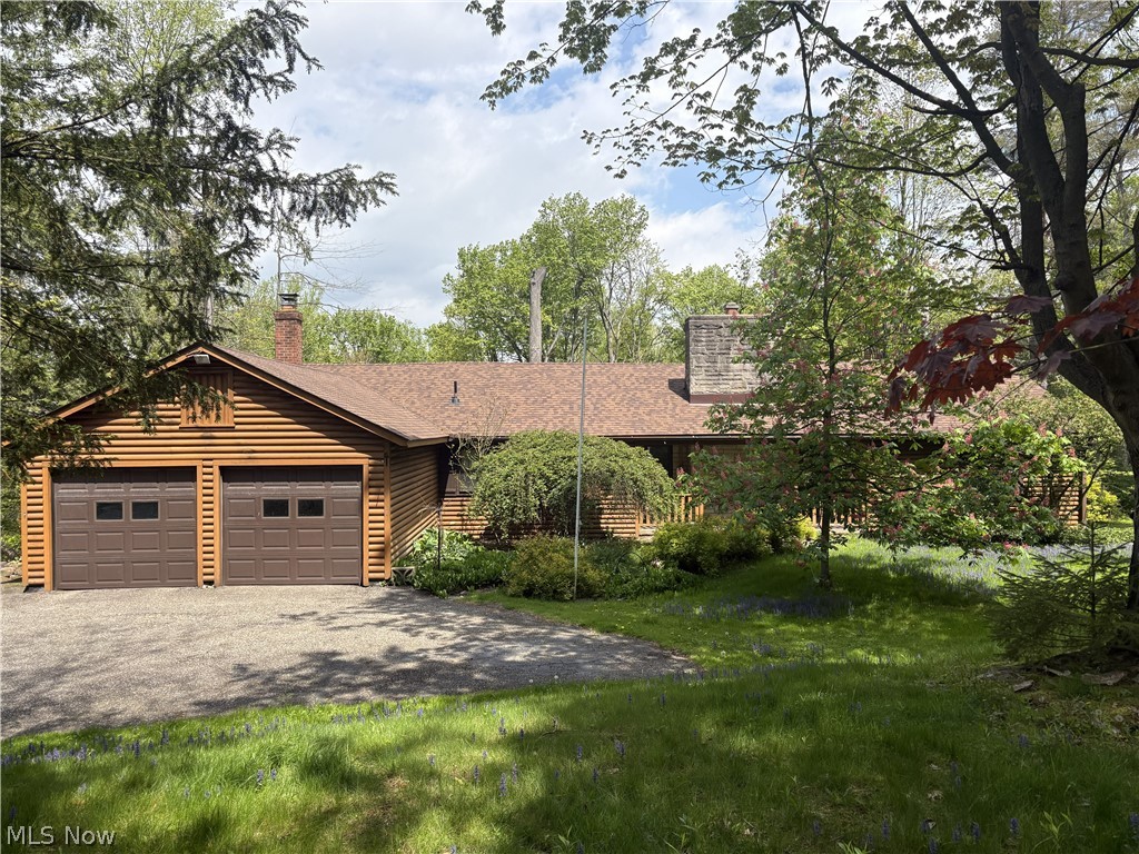 Nestled in the woods in Munson Township, is a spacious log cabin home, with 4 bedrooms and 2 and a half baths. This home sits on 3.72 acres of picturesque land with views of the woods, ravine, rock piles, and more.  Nature truly does surround you here. The wormy chestnut walls and ceilings in the living room and kitchen give this home so much warmth and country charm. The two stone fireplaces, one in the family room (with a blower) and one in the living room, were hand built from rocks found on the wooded grounds. The primary bedroom plus two more are on the main level.  There are two full baths plus a half bath on the main level also. Up the staircase with a hand carved railing, you will find the 4th bedroom, and also a great big attic for storage. There is a large dine in kitchen too. Just look out the large picture window in the kitchen and enjoy the views of the lush woods, as birds and woodland animals play. An enclosed porch is right off the living room in the rear of the house which also offers fabulous views. There is a two car attached garage, that leads into the laundry room/mud room.  There is a shed or small cabin on the property that could serve many purposes. In 2025 a new roof was put on, along with some gutters, and also a new hot water tank. Come see this truly unique home, and enjoy peaceful country living.