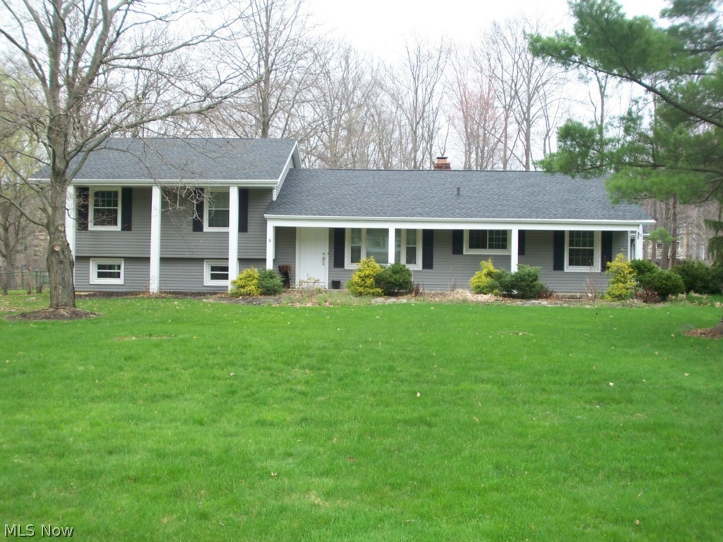 An exceptional Hudson split level on .69 acres.  The rear yard is completely fenced, with an amazing patio and hot tub.  A huge focal fireplace sets off a large living room.  The lower level features a family room, and is a walk out.  The large galley kitchen has an eating area.  The many updates include: roof, gutters, siding, refinished floors, patio, windows, furnace, and much more.  The bedrooms are spacious, with a master suite.  There is an attached two car garage, bonus room off of the living room, and a front porch large enough to enjoy.