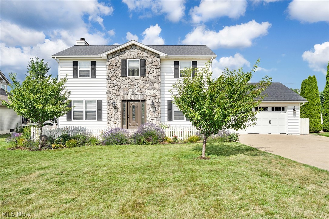 From the moment you pull up, you’ll be captivated by the home’s striking curb appeal. A beautiful stone-front entry, charming white picket fence, and vibrant wildflowers and seasonal blooms create an inviting first impression that feels straight out of a storybook.

Step through the front door and into a warm, welcoming foyer that opens to a spacious and thoughtfully designed floor plan. A bonus room to the right that can be your choice of a dining room or office. To the left is a living area. Straight ahead you’ll pass a conveniently located half bathroom. The heart of the home is the open-concept kitchen complete with generous cabinet and counter space, facing a beautiful stone fireplace. Whether you’re hosting family gatherings or enjoying a quiet evening at home, this space was designed to bring everyone together.

Upstairs, you’ll find four spacious bedrooms and 2 full bathrooms, including a comfortable primary suite that offers the perfect place to unwind after a long day. Each bedroom provides ample space for family, guests, or a home office.

Head downstairs to the partially finished, waterproofed basement, where you’ll find another beautiful stone fireplace. The basement offers endless possibilities for a recreation room, home gym, playroom, or additional living space while still providing plenty of storage.

Step outside and discover your own private backyard retreat. The fully fenced yard is ready for summer fun with a wonderful deck, hot tub, and above-ground pool—the perfect setting for barbecues, relaxing evenings, and making memories with family and friends.

Located in the sought after Cimarron neighborhood in Columbiana, this move-in-ready home offers the perfect blend of comfort, functionality, and outdoor living. From the gorgeous landscaping to the inviting interior and backyard oasis, 144 Hawkins Ave is ready to welcome you home.

This is more than a house—it’s a place you’ll love coming home to. Schedule your private showing today!