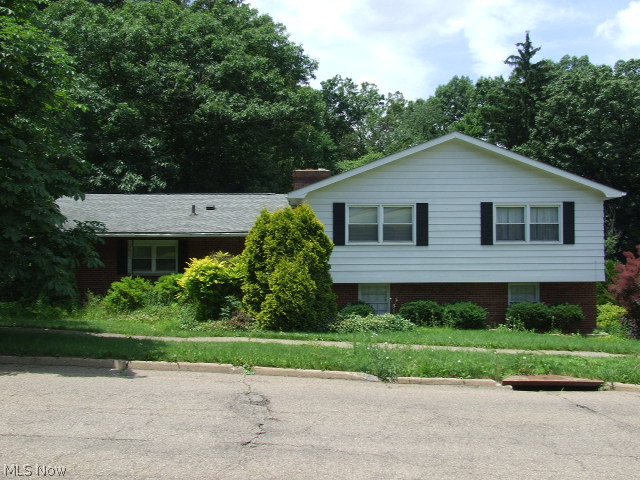 Great 4-level split with large rooms and fantastic views.  First floor has nice size living room and step-up dining room, both with hardwood floor and large picture windows overlooking the hills and trees of Sand Run Park.  Super kitchen is the length of both the Living Room and Dining room, giving you tons of cupboards and counters with eating area.  Upper level has 4 big bedrooms and two full bathrooms, including the master bathroom.  Lower level has a huge family room with fireplace and slider to sunroom, overlooking the park again.  This level also walks out to the attached 2-car garage.  Final lower level includes half bath and rec room with built-ins including bar area, hot tub (not sure if it works) and sliders to the patio and rolling backyard.  A few loving touches and this could be a wonderful Home.