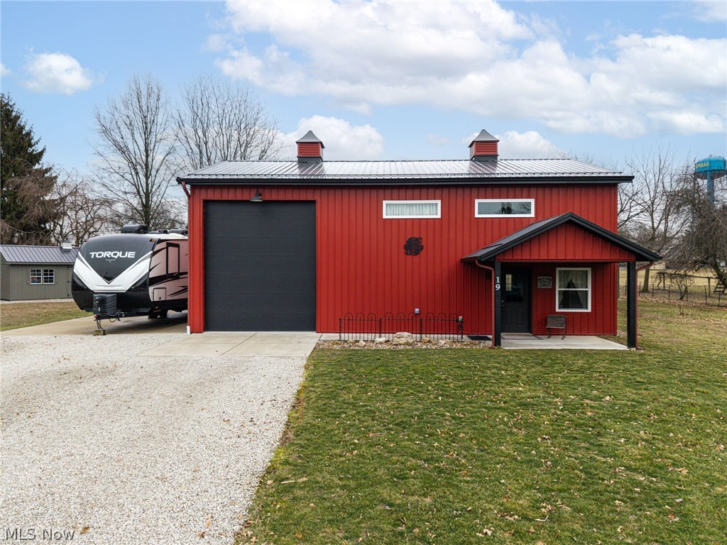 Welcome to this unique and beautifully built barndominium, tucked away on a quiet dead-end street in a peaceful township near Haysville. Built in 2020, this thoughtfully designed home sits on nearly ¾ of an acre with open land behind it, offering privacy, space, and a modern rural feel. Step inside to an inviting open floor plan that seamlessly connects the kitchen, dining, and family room areas—perfect for both everyday living and entertaining. The kitchen comes fully equipped with all appliances staying, and the space is highlighted by abundant recessed lighting throughout the home. The main level features a large full bathroom with generous storage, along with a spacious laundry and mudroom that also offers additional storage. Upstairs, a versatile loft area includes double closets and provides flexible space for a bedroom, office, or additional living area. The attached garage is built to impress with 16-foot ceilings, a 14-foot insulated commercial garage door, and its own gas heat, making it ideal for vehicles, hobbies, or workshop space. Quality construction continues with 6-inch thick concrete walls between the home and garage, along with a 6-inch thick concrete driveway and garage floor reinforced with rebar and fiber mesh. The property is equipped with 200-amp service and dual inverters for efficient heating and cooling. Step outside to enjoy the covered back porch, a perfect place to relax and take in the quiet surroundings. The property also includes two large freshly painted sheds—one 12×20 with electric and partially finished interior, and another 12×24 for additional storage or workspace. With modern construction, quality materials, and a peaceful setting just minutes from town conveniences, this one-of-a-kind property offers the perfect blend of functionality, efficiency, and country charm.