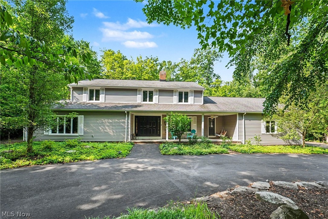 Welcome to 7850 Mayfield Road! This spacious and beautifully updated Colonial is ideally located in the highly desirable Village of Gates Mills, offering the tranquility of country living with the convenience of nearby shopping, dining, and commuter routes. A charming covered front porch and double-door entry welcome you into the classic center hall floor plan featuring refinished hardwood flooring throughout the entire first floor, formal living and dining rooms, and an updated guest powder room. The inviting family room boasts a beamed ceiling, brick-faced wood-burning fireplace, custom built-ins, and a wet bar that also serves as the perfect hobby or study area, with sliding glass doors leading to the expansive deck and private backyard. Renovated in 2019, the well-appointed kitchen features granite countertops, a breakfast bar, five-burner electric cooktop, double wall ovens, oversized standalone refrigerator and freezer, abundant cabinetry, multiple pantries including an oversized walk-in pantry, and a casual dining area with French doors to the deck. The rear hallway includes a spacious laundry room with built-in cabinetry, a planning center, terrazzo flooring, an additional powder room, and direct access to the attached three-car garage. Upstairs are five generous bedrooms, including a vaulted primary suite with a walk-in closet, updated vanity, and private bath, while two bedrooms share the hall bath, another enjoys its own adjacent full bath, and the fifth bedroom is privately tucked away, making it ideal for guests or a home office. The finished lower level offers both a recreation room and game room, while the unfinished area houses the newer furnace and hot water tank and provides exceptional storage. Combining generous living spaces, thoughtful updates, outstanding storage, and a flexible floor plan, this exceptional Gates Mills home is ready to welcome its next owner.
