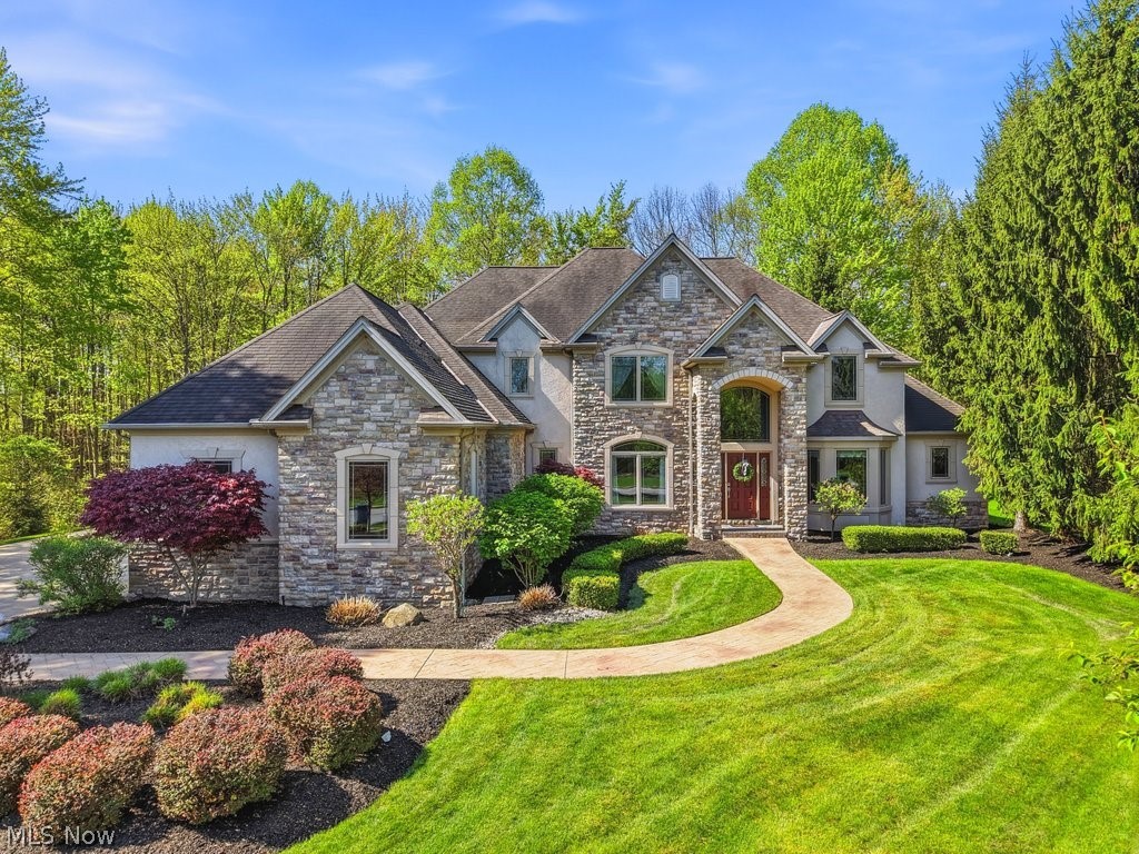NEW PRICE! Nestled in Solon's premier golf course community, Signature of Solon, this exceptional custom colonial delivers the perfect blend of elegance, comfort, and thoughtful design. A beautiful paver walkway leads to a dramatic vaulted foyer, setting the tone for the refined finishes found throughout. The soaring two-story great room features a wall of windows with custom draperies, gas fireplace, and built-ins. The gourmet kitchen impresses with high-end maple cabinetry, granite counters, a center island with breakfast bar, stainless appliances including Sub Zero refrigerator 4 burner gas range w/gridle, wall oven and microwave — flows seamlessly into the hearth room, formal dining room, and a stunning three-season screened in porch with slate flooring and a 12-ft wood ceiling. The FIRST FLOOR OWNER'S SUITE is a true retreat, boasting a tray ceiling, his-and-hers walk-in closets, a see-through gas fireplace shared with the spa-like bath featuring a whirlpool tub, double vanity, and walk-in shower. A private office with French doors, bay window, and checkerboard wood ceiling completes the main level. Upstairs offers three generous bedrooms, two full baths, and a massive bonus room with built-ins — ideal as a fifth bedroom or second family room. The fully finished basement features a granite bar, recreation spaces, and a dedicated home theatre. Additional highlights: 4-car heated side-entry garage with loads of cabinets, extra-wide driveway, hardwood floors, zoned heating and cooling, walk-in attic, 3 gas FP's and 2 power rooms on the first floor and a private lot backing to HOA land. Residents enjoy a championship golf course, heated pool, tennis courts, fitness center, and a clubhouse with fine dining. Top-rated Solon Schools! Updates Include: Painted Bedrooms 2026 One New HVAC Unit-2025 Garage Door Openers-2025 New Dryer-2025 New Wine Frig-2025 Exterior Stucco Trim Painted-2024 New Washer-2022 New Dishwasher-2022 Interior paint-2021 Hall Beadboard and lockers.