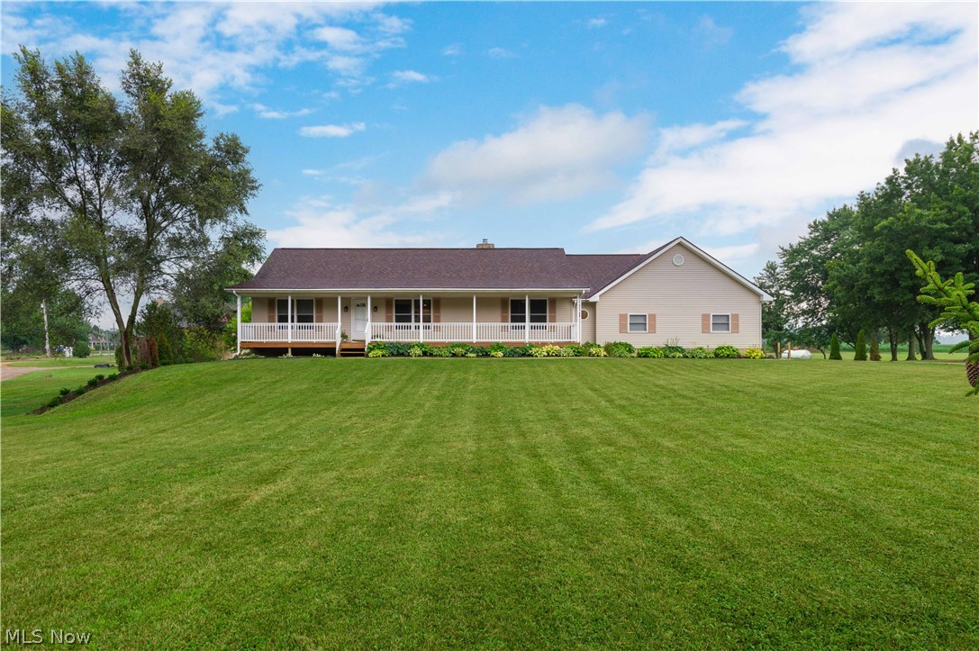 Welcome to this beautiful country retreat, perfectly situated just outside the city, offering the peace and privacy of country living with the convenience of nearby shopping, dining, and everyday amenities. Nestled on 2.26 scenic acres and surrounded by farmland, you'll enjoy picturesque views and a true countryside atmosphere from the moment you wake up. Relax on the inviting farmhouse-style front porch as you watch summer storms roll in, or entertain on the newly installed rear deck overlooking the expansive backyard. The exterior has been thoughtfully updated with a brand-new roof, an extended concrete driveway, fresh landscaping featuring mature hostas, a partially fenced yard, and a lower poured patio accessible from the walk-out basement. Inside, this home has been beautifully updated from top to bottom and is truly move-in ready. The open-concept main level offers a warm and inviting living space centered around a cozy wood-burning stove. The fully remodeled kitchen features granite countertops, modern finishes, and flows seamlessly into the living and dining areas. Durable Coretec flooring extends throughout the home, complemented by fresh paint and stylish updates in every room. The main floor includes three generously sized bedrooms, two updated full bathrooms, including a stunning primary suite with a brand-new tiled walk-in shower, and the convenience of first-floor laundry with new butcher block countertops. The newly finished walk-out basement significantly expands the living space with a fourth bedroom, a spacious recreation room featuring two custom accent walls, an additional full bathroom, and a utility room with hookups for a second laundry area. The oversized garage provides exceptional storage space, and fiber optic internet offers fast, reliable connectivity for work or entertainment. Every detail has been thoughtfully completed, allowing you to simply move in and enjoy everything this exceptional property has to offer.