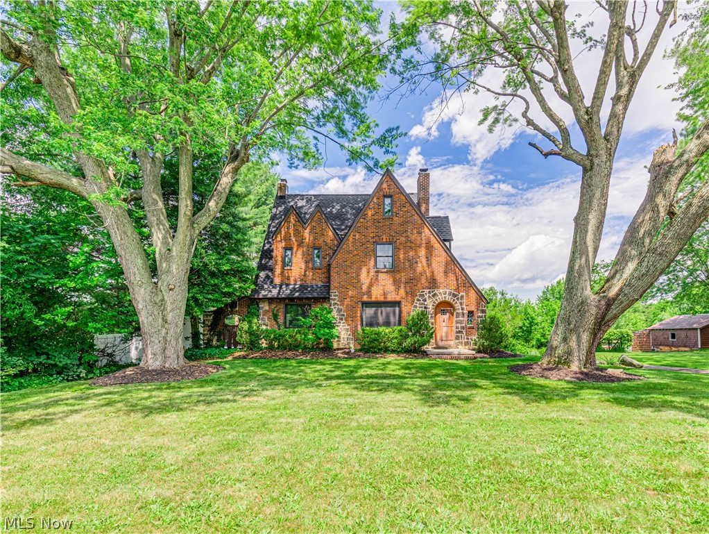 Step into a storybook setting with this charming 3-bedroom, 1.5-bath Tudor home nestled on a picturesque 1.76-acre lot. Bursting with character at every turn, this lovingly maintained property seamlessly blends timeless charm with thoughtful modern updates, creating a warm and inviting place to call home. Inside, you'll find unique architectural details, cozy living spaces, and not one, but two fireplaces to enjoy year-round. The stunning stone fireplace in the living room offers the convenience of gas heat while the brick wood-burning fireplace creates the perfect gathering space in the finished lower level. An enclosed side entry provides a practical and welcoming transition into the home while the side porch offers a peaceful spot to enjoy your morning coffee. Recent updates provide peace of mind, including most windows (energy efficient) (2025), roof and gutter guards (2025), upstairs carpeting (2024), hot water tank (2024), water softener (2024), furnace (2020), septic system replacement (2018), and newer appliances. The washer and dryer are also included, making this home truly move-in ready. Upstairs, the owner's bedroom offers a rare and desirable retreat featuring separate his-and-hers closets along with a walk-in vanity closet for added convenience and storage. Outside, the possibilities are endless. Enjoy summer days by the above-ground pool with surrounding deck, entertain guests beneath the covered patio and pavilion complete with electric or unwind in the privately fenced side yard featuring a stamped concrete patio and electric service. The expansive backyard provides plenty of room for recreation, gardening, and outdoor gatherings, while the 3-car garage with attached shed offers exceptional storage and workspace. From its charming Tudor character to its beautiful outdoor spaces and extensive updates, this one-of-a-kind property offers the perfect blend of comfort, functionality, and timeless appeal. Come experience the warmth and charm for yourself.