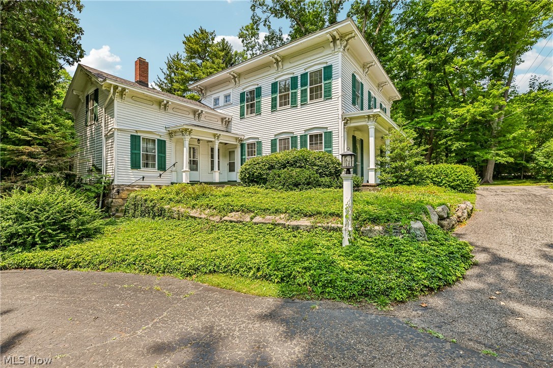 Welcome to this timeless 1884 Colonial nestled on nearly 5 picturesque acres in desirable Twinsburg. Offering over 3,000 square feet of living space, this character-filled home blends historic charm with everyday functionality. Step inside to discover soaring 9-foot ceilings, beautiful original woodwork, spacious rooms, and both front and rear staircases that add to the home's classic appeal. The heart of the home features a generous kitchen with a pantry area that opens to the inviting family room highlighted by a cozy fireplace, creating the perfect gathering space for family and friends. A convenient first-floor full bath, utility room, and laundry room add everyday practicality. The second floor offers four spacious bedrooms and a full bath, while the rear staircase leads to a versatile loft area—ideal for a home office, studio, playroom, or additional living space. Enjoy peaceful mornings and relaxing evenings from the screened back porch overlooking the beautiful property. Outside, you'll appreciate the circular driveway, mature trees, and a detached 720-square-foot garage complete with a second-story loft offering exceptional storage, workshop space, or future possibilities. The full basement includes an exterior entrance for added convenience. Major improvements include a new roof (2006) and HVAC system (2015). The home is serviced by city water and a private septic system. Located in the award-winning Twinsburg School District, this property offers the perfect balance of privacy and convenience. Just minutes from shopping, restaurants, parks, golf courses, Metro Parks, and major highways including I-480, I-271, and the Ohio Turnpike, commuting to Cleveland, Akron, or surrounding communities is effortless. Rarely does a property combine historic elegance, acreage, and such an outstanding location. Don't miss this exceptional opportunity!