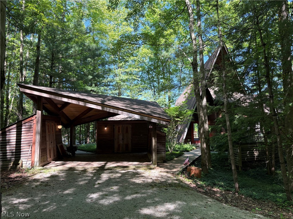 Tucked away in the woods on a quiet cul-de-sac, this stunning post-and-beam home blends rustic charm with breathtaking lakefront living. Designed with the character of an A-frame retreat, the home sits on a secluded 3/4-acre lot surrounded by nature, offering privacy, tranquility, and spectacular views from nearly every angle.

Inside, the soaring vaulted great room is filled with natural light and opens to an expansive deck overlooking the lake — the perfect setting for entertaining or simply enjoying peaceful mornings and sunsets. A spacious loft overlooks the great room, while an additional third-floor loft adds even more character and flexible living space. The warm and inviting eat-in kitchen creates a welcoming gathering place for family and guests alike.

Outdoor living is equally impressive. Boardwalks weave throughout the property, leading to a private dock and sandy beach for effortless lake access. Sports enthusiasts will love the elevated, lighted tennis and pickle ball court, while the screened gazebo and outdoor shower complete the ultimate lakeside lifestyle experience.

Meticulously maintained and thoughtfully designed, this one-of-a-kind retreat offers the perfect combination of architectural beauty, recreation, and serene waterfront living.