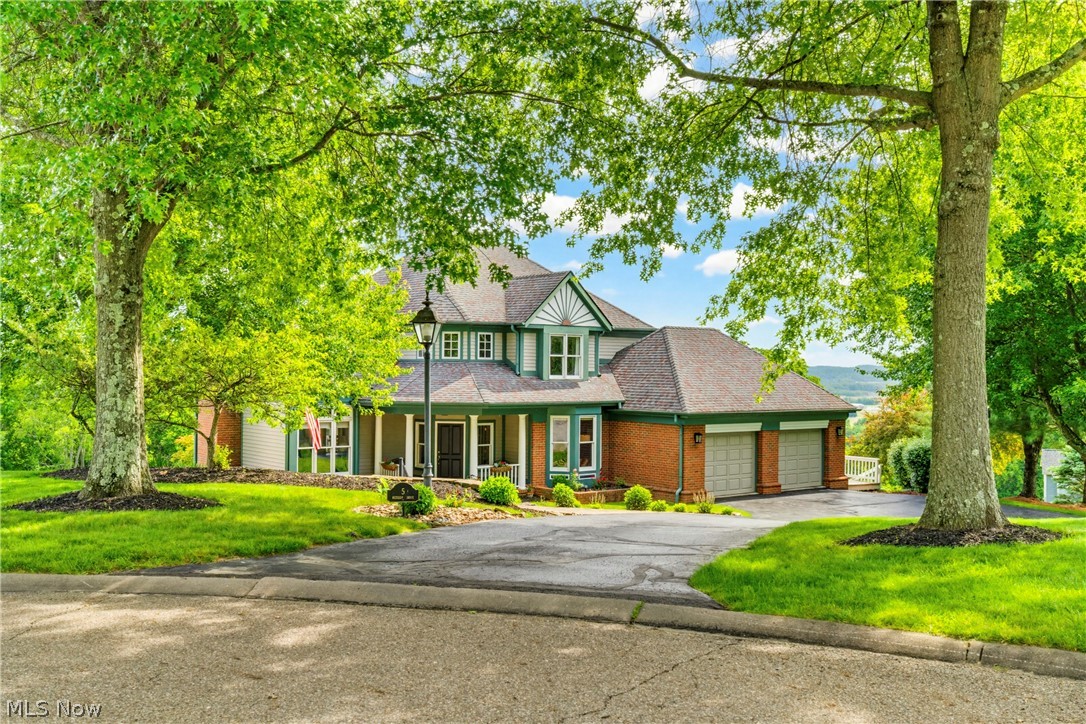 Perched high above the historic charm of Roscoe Village in the sought-after Roscoe Hills subdivision, this custom-built home offers a lifestyle that is increasingly hard to find. Combining exceptional craftsmanship, generous living spaces, and breathtaking views of Coshocton County, this home feels both grand and welcoming from the moment you arrive. Step through the front door into a dramatic foyer where the home's thoughtful design immediately unfolds. To the left, a stunning living room creates the perfect setting for entertaining and everyday living, while a private office with glass doors sits to the right. Straight ahead, a grand staircase serves as the focal point of the entry and sets the tone for the quality found throughout. The heart of the home is the beautifully designed kitchen featuring custom Amish-built cabinetry, abundant workspace, and an open dining area enhanced by custom built-ins. Just beyond, a sunroom filled with natural light provides the perfect place to enjoy morning coffee while taking in the surrounding views. The first-floor owner's suite offers convenience and comfort, complete with a spacious walk-in closet and private retreat feel. A mudroom and half bath complete the main level. Upstairs, you arrive at a welcoming loft and hang out/homework zone. Then there are three generously sized bedrooms with impressive closet space and a full bath. One walk-in closet even provides access to extensive attic storage and the home's second HVAC system. The walkout lower level is designed for entertaining and everyday enjoyment. This expansive space features a large family room, bar area, recreation space, and full bath. Open the doors and step onto the patio, where the most spectacular views serve as the backdrop for relaxing evenings, family gatherings, and unforgettable sunsets. Rarely does a home combine custom craftsmanship, timeless design, incredible functionality, and breathtaking views so effortlessly. This is luxury living.