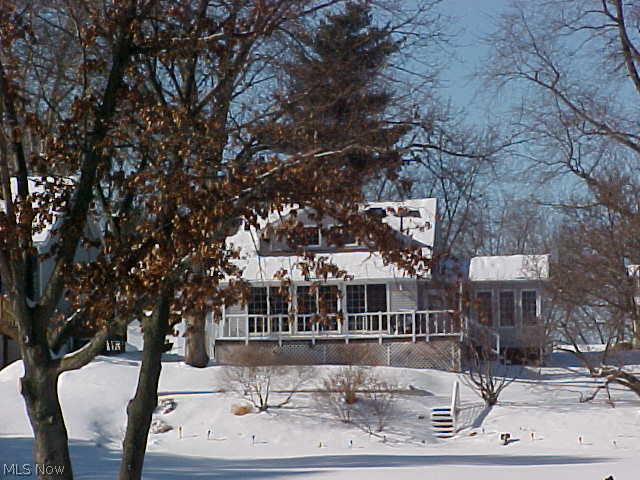 Enjoy the year round living on this lakefront property. Newer 80' sea wall with 3 hooks ups and electric. Lovely Cape Cod home with a first floor master. Wonderful view of the water from the newer kitchen, dining area, sun room and deck. Gas log fireplace in Living Room with a bonus room that could be office, more dining area or sitting area. Sun Room with cathedral ceiling, lots of windows and a hot tub. Both baths have been updated.  Many major updates throughout the home, windows, electric, air, furnace, gutters and down spouts, whole house fan and roof. Storage barn-property is on 6 lots.