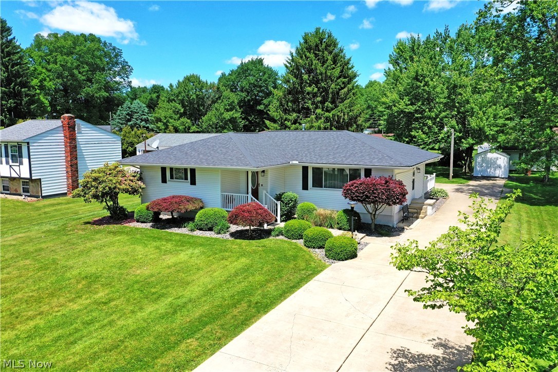 The most darling Lordstown ranch is hitting the market, and you just might be the lucky individual to call it your own as you enjoy the summer! Expertly kept from the inside out, you’ll first notice the colorful and manicured landscaping that lines the bright cement driveway as it extends past the home to find a relaxing, raised rear patio and a large, two-car garage plus a bonus storage shed. A fenced in side-yard creates a safe place for pets or children as a hot tub awaits nearby, taking advantage of the privacy. Step inside to find a bright and welcoming living room, presenting warm hardwood flooring and plenty of natural light. Around the corner, enjoy the inviting dining space that overlooks the masterfully updated kitchen with its glass tile backsplash and contemporary country styled cabinets. Stepping down, a sunken finished breezeway provides an easy four-season entertainment venue or an easy place to relax with a favorite book. Further down the hall, an incredible full bath includes first floor laundry service with its stacked units. The trio of bedrooms increase in size, ending at the carpeted master bedroom. Downstairs, open finished rec space is a canvas to your creativity. An additional full lower bath hides a more prominent lower laundry operation with bonus hidden storage. 
Beautiful Four Season room adds 160 sq. ft. to the home. Laundry upstairs and downstairs, Roof, gutters, siding and fascia 2020, Furnace / AC and HWT 2021, All appliances 2022, Subpanel 2022, Stack washer and dryer 2024, Water Softener 2023, downspouts to street 2020 and Weather Tight Windows 2005. The shed in the back does not stay with the home.