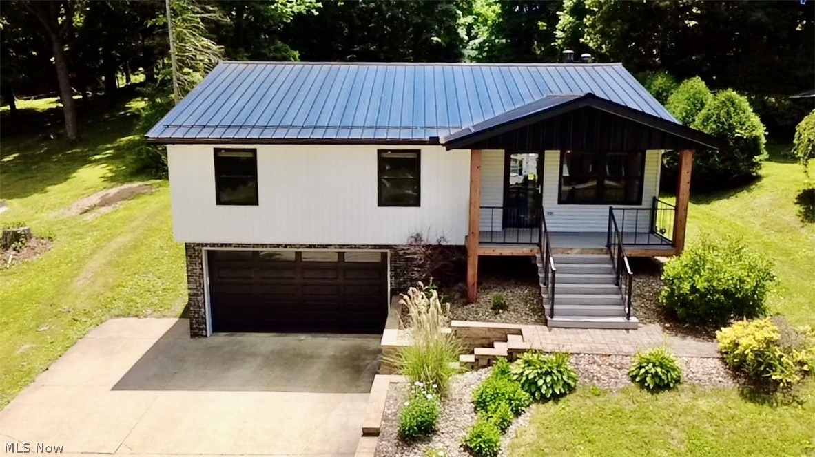 Completely updated inside and out, this striking 4-bedroom, 3-bath home in the sought-after Rivermoor Estate neighborhood delivers modern style on an expansive 0.44-acre lot. The eye-catching exterior features fresh vinyl siding and a bold architectural roofline, while the interior showcases a fully renovated kitchen with updated cabinetry, designer pendant lighting, and all appliances included — refrigerator, range, microwave, dishwasher, washer, and dryer. The open living area centers around a gas fireplace, and the finished basement adds versatile living space along with a convenient half bath and dedicated laundry room. Three stylishly updated bathrooms feature on-trend finishes including shiplap accents, statement mirrors, and modern vanities. Each of the four bedrooms offers personality and space, with hardwood-style flooring and unique design details throughout. Outside, tiered landscaping and stone retaining walls give the property incredible curb appeal, while a covered deck and front porch provide the perfect setting for outdoor living. The attached 2-car garage with opener and drains adds everyday practicality, and a storage shed/outbuilding offers even more utility. Served by the Mogadore Local School District and just minutes off Rt. 224, this turnkey home checks every box — schedule your showing today before it's gone.