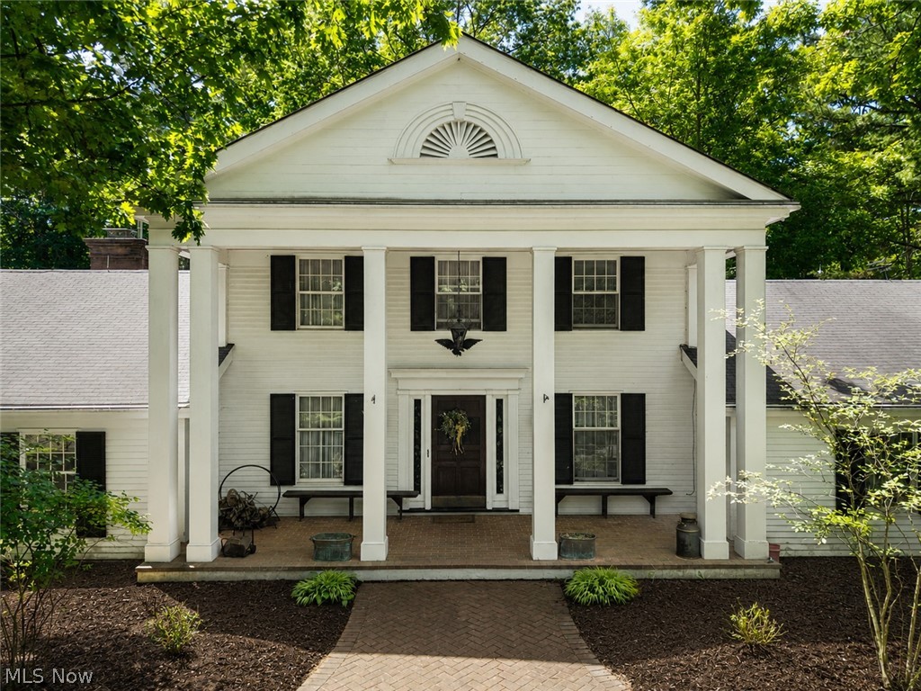 Timeless Colonial Estate on 4.15 Acres in the Heart of Brecksville-Commanding presence meets everyday livability at this extraordinary Colonial estate set on 4.15 acres of lush, wooded grounds in one of Brecksville's most coveted corridors. With its grand columned portico, classic fanlight pediment, & sweeping lawn, this home makes a statement from the moment you arrive & continues to impress at every turn. Step through the rich wood entry door into a foyer finished w/ slate tile flooring & a striking staircase - a fitting introduction to the thoughtful craftsmanship found throughout. The vast great room commands attention w/ vaulted ceilings, hardwood floors, a wood-burning fireplace, and a dramatic curved staircase balcony, a truly show-stopping space for entertaining or everyday living. The heart of the home is a spacious, well-appointed kitchen offering rich wood cabinetry, a center island w/ cooktop, double wall ovens, generous counter space, & multiple windows overlooking the private backyard, a functional space w/ serious potential for the next owner's personal touch. Another great feature is the incredible lower-level rec wing, complete w/ sitting area under dramatic exposed wood beam ceilings, a stone fireplace, bonus room, full bathroom & access to the wooded backyard through sliding glass doors. The home's character shines in its unique details: a sunroom/family room w/ wood-paneled ceilings and an entertainment wall, an impressive dining room w/ exposed brick walls, parquet flooring, & wall-length cabinetry. 3 car attached garage & 2 car detached garage! The property conveys w/ 2 parcels — Home sits on 2.5 acres & comes w/ a 1.65-acre adjoining lot, offering privacy, expansion potential/future opportunity, Brecksville's acclaimed school district & minutes from the Metroparks, I-77, & all the conveniences of this sought-after community. This is not just a home — it's a legacy property waiting for its next chapter.
