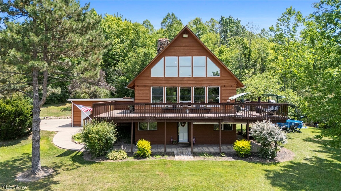 Welcome to this distinctive A-frame home set on 5.69 private acres in Chardon, offering rustic character, functional living space, and a peaceful wooded setting. Inside, the open main living area is filled with warmth and charm, featuring soaring ceilings, exposed beams, rich wood finishes, and a striking stone wood burning fireplace. The living room flows into the dining area and kitchen, where you will find butcher block style countertops, stainless steel appliances, open shelving, and a center island with breakfast bar seating. Two bedrooms and a full bathroom are located on the main level. Upstairs, the private master suite offers a true retreat with a sitting area overlooking the living space, scenic views, and an updated full bath with walk in shower and stone finishes. The finished walkout lower level provides exceptional bonus space with a second wood burning fireplace, full wet bar, additional full bathroom, laundry area, and room for entertaining or relaxing. Outside, enjoy the wraparound deck, lower patio, and beautiful natural surroundings. Additional recent mechanical and water system updates add to the home’s overall value and functionality. A rare opportunity to own a truly distinctive home with privacy, character, and space to enjoy in every season, just minutes from Alpine Valley with views of the ski resort from the property.