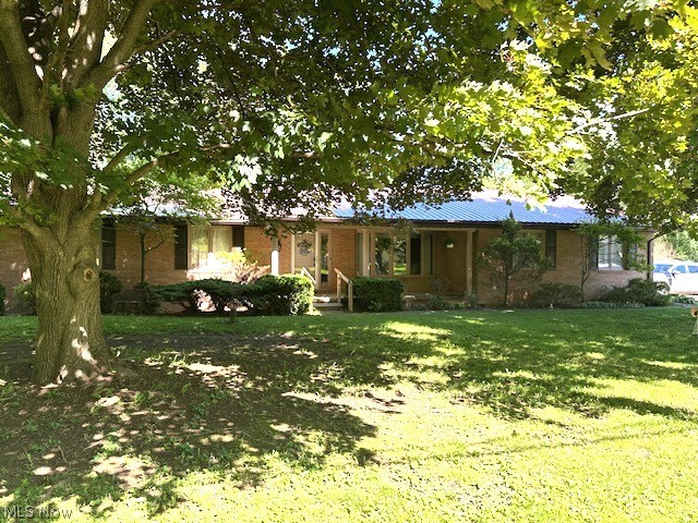 Lovely one-owner home.  Brick ranch with a rural setting & plenty of entertainment space!  Home features a large covered front porch and a four-season sunroom with french doors to a private patio.  First floor family room with a fireplace adjoins the kitchen.  Large front living room, formal dining off the kitchen and 3 bedrooms with a half bath for the master completes the large square footage on the main floor.  The lower level is partially finished with a great recreation room and also has utility/laundry space and a workroom. 2 Car garage with lots of extra parking in the driveway. The back yard has a 12x14 storage shed with metal roof and a wonderful 12x12 gazebo for relaxing or reading on warm summer days.  All appliances stay, home and storage shed have metal roofs.  Just minutes from Minerva or East Canton and easy access to anywhere in Stark County.    Just enough land to enjoy but not too much to maintain!