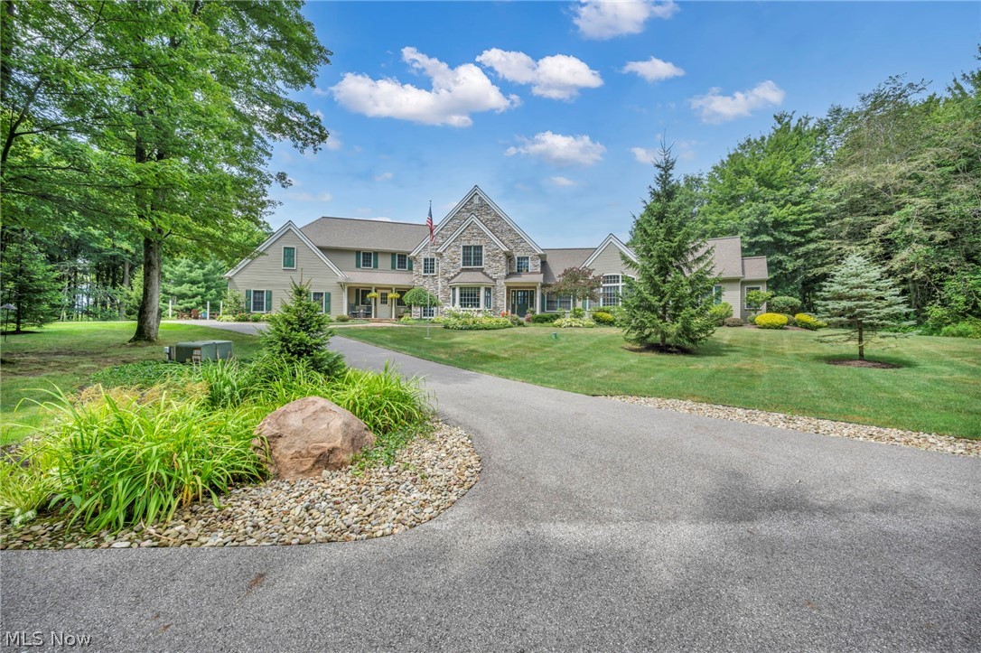 Private 30-Acre Outdoor Retreat Near Downtown Chardon. Tucked at the end of a private drive, this custom French Country estate offers an exceptional blend of elegance, privacy, and outdoor adventure. Just 3.5 miles from Chardon Square and 10 miles from Route 90, this nearly 30-acre property is a dream for outdoorsmen and nature lovers alike. Explore 21 acres of mature hardwood forest, 5 acres of open pasture, and 3 acres of scenic frontage—ideal for hunting, hiking, or simply enjoying nature’s tranquility. Currently enrolled in CAUV for a 50% tax savings, the property combines beauty and practicality. A 900-foot asphalt driveway leads to the stately residence, where timeless architecture meets modern comfort. The main-level owner’s suite (2018) offers heated floors, dual walk-in closets, a luxurious microbubbler soaking tub, and walk-in shower. A two-sided wood-burning fireplace connects the kitchen’s dining area with the great room, creating a warm, inviting flow. Upstairs, find three spacious bedrooms, including a Jack and Jill bath and a cozy loft workspace. A dedicated home office near the foyer provides quiet productivity, while the finished lower level (2020) includes a full kitchen, full bath, fitness or guest space, and direct access to a stamped-concrete patio perfect for entertaining. The 4-season sunroom and expansive back deck overlook rolling pastures and manicured landscaping. Outdoors, enjoy a 24x40’ two-story barn with an unfinished upper level, a 10x16’ she-shed, and a 9,000-watt generator for peace of mind. The 350-foot spring-fed well provides pure water without treatment. This property offers rural luxury at its finest—secluded yet sophisticated, peaceful yet practical. A rare opportunity to own a private country estate with every modern convenience and endless opportunity to explore the outdoors.