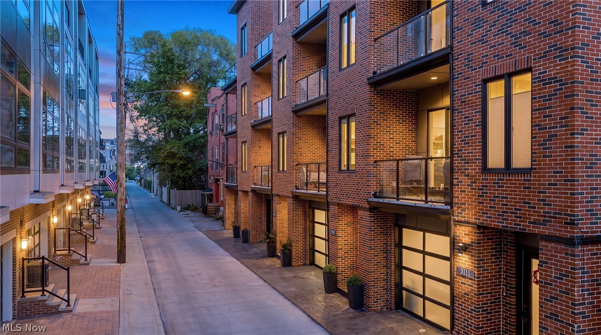 This is your opportunity to own one of Ohio City's most refined newly built townhomes. Set on one of Hingetown's most sought-after blocks and delivered with an extraordinary level of craftsmanship and design intention. FULL City of Cleveland Tax Abatement through 2039, saving the new owner $15–$20k annually. This benefit is made possible through green energy compliance built into the home's construction. The classic brick façade, heated THREE-car garage and 4 outdoor balconies and terraces create exceptional curb appeal and a lifestyle few builds can match. Inside, the home is highlighted by ten-foot ceilings, expansive windows, wide-plank wood floors, Kohler fixtures and a dramatic floating single-stringer metal staircase - creating a sense of space and sophistication. The primary living level is built for entertaining with its showpiece kitchen featuring custom Amish-built cabinetry, oversized island with waterfall quartzite and matching backsplash, and a full suite of top-of-the-line appliances (36" gas cooktop, built-in microwave, counter-depth refrigerator). The kitchen flows into a generous entertaining space, bright living area and dining room with slider access to balcony. Each bedroom is its own retreat with full tile baths and floating vanities with quartzite counters. The primary suite stands apart — a sanctuary with walk-in closet, walk-in shower, dedicated office, and private balcony. On the top floor, a spacious bedroom with custom built-in bar and wide hallway provides direct access to the crown jewel — a double terrace. A beautifully appointed full bath completes the floor. The outdoor living is unmatched: a partially covered terrace anchors 3-season entertaining, while the rooftop delivers sweeping views of Lake Erie and the Cleveland skyline. Two blocks from Ohio City's celebrated cafes, restaurants, and boutiques. Minutes from Tremont, Gordon Square, Edgewater Park, and the Lake Erie Bikeway. Downtown Cleveland is a short drive or bike ride away.