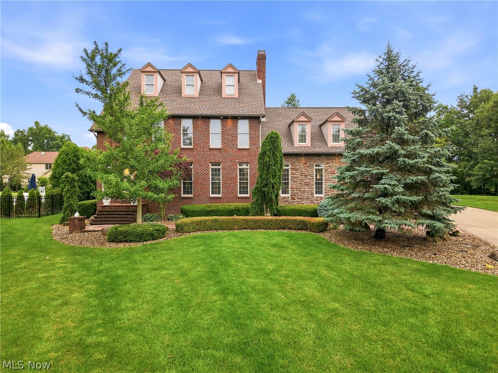 Located in the desirable Villa Rosa development within the Canfield Local School District, this custom-built brick and stone colonial offers exceptional craftsmanship, luxury finishes, and outstanding indoor-outdoor living. Featuring 4 bedrooms, 3.5 baths, a finished lower level, and an attached 3-car garage, this impressive home blends timeless design with modern functionality. A grand foyer welcomes you inside, where maple hardwood flooring flows throughout the main level. The living and dining areas are enhanced by crown molding, abundant natural light, and a dual-sided ventless gas fireplace serving both the living room and grand kitchen. Designed for entertaining, the chef's kitchen features soaring 18-foot ceilings, commercial-grade JennAir appliances, Corian countertops, dual islands with a prep sink and butcher block workspace, a walk-in pantry, and custom inset maple cabinetry. The dramatic floor-to-ceiling stone and brick fireplace creates a striking focal point while the open layout provides exceptional space for cooking, gathering, and everyday living. The main level also includes a laundry room and powder room. Upstairs, the owner's suite offers a marble bath with a walk-in shower, soaking tub, private water closet, and walk-in closets. Two additional bedrooms are connected by a Jack-and-Jill bath. The finished lower level expands the living space with a recreation room featuring a stone fireplace and custom built-ins, a fourth bedroom, a full bath, and direct access to the attached 3-car garage. Outdoor living is highlighted by a covered stone patio, gas fire pit, professional landscaping, and multiple spaces for relaxing and entertaining. The property is pool-ready and enclosed by a 6-foot aluminum fence. Combining luxury finishes, spacious living areas, and a sought-after Villa Rosa location, this exceptional home presents a rare opportunity in one of Canfield's premier communities.
