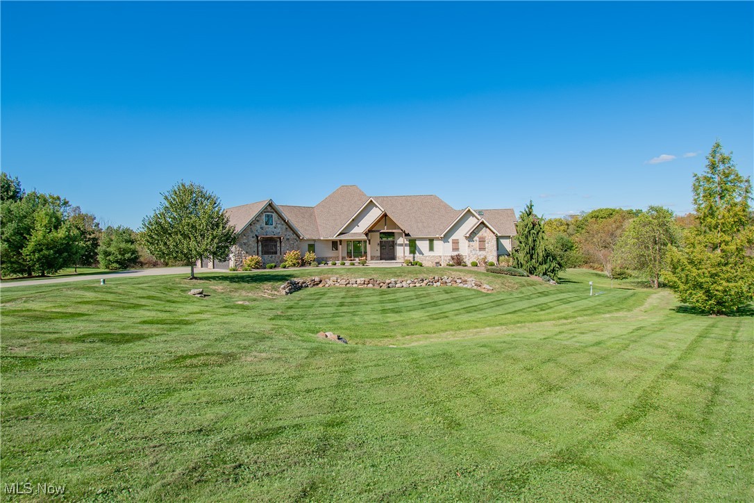 Your dream home awaits! Welcome to this breathtaking luxury ranch estate, perfectly situated on over 3.5 acres of private, picturesque landscape. Designed with comfort, craftsmanship, and modern sophistication in mind, this home offers an exquisite balance of open-concept living and timeless elegance. Step inside to discover an expansive open floor plan framed by 10–15-foot ceilings, creating an airy, grand atmosphere throughout the main level. The great room is the heart of the home, featuring a gas-vented fireplace with a custom stone surround and mantle beam, complemented by a wall of windows that fill the space with natural light and showcase serene views of the property’s large backyard pond and waterfall. The chef’s kitchen is an entertainer’s dream, boasting two oversized islands, two dishwashers, a large cooktop, and a walk-in pantry, all beautifully remodeled with the butler’s pantry in 2022. A charming eat-in area overlooks the backyard, while a formal dining room provides an elegant setting for gatherings. Retreat to the primary suite, a true sanctuary offering a private fireplace, his-and-hers walk-in closets, dual vanities, a soaking tub, a standing tile shower, and a private toilet room, complete with in-suite laundry hookups. The finished walk-out basement expands your living options with a kitchen, living area, and four oversized bedrooms. The lower level also includes a second laundry room, perfect for multi-generational living or guests. This home is fully insulated and energy efficient, featuring dual heating systems and 10 independently zoned heating and cooling areas. A dedicated pet room with a built-in pet shower adds convenience. Outdoors, enjoy tranquil mornings on the freshly sanded and painted deck (2025) overlooking your private pond. The five-car garage provides abundant storage and workspace. From its elegant interiors to its serene surroundings, this is more than a home, it’s a lifestyle of refined luxury and peaceful living.