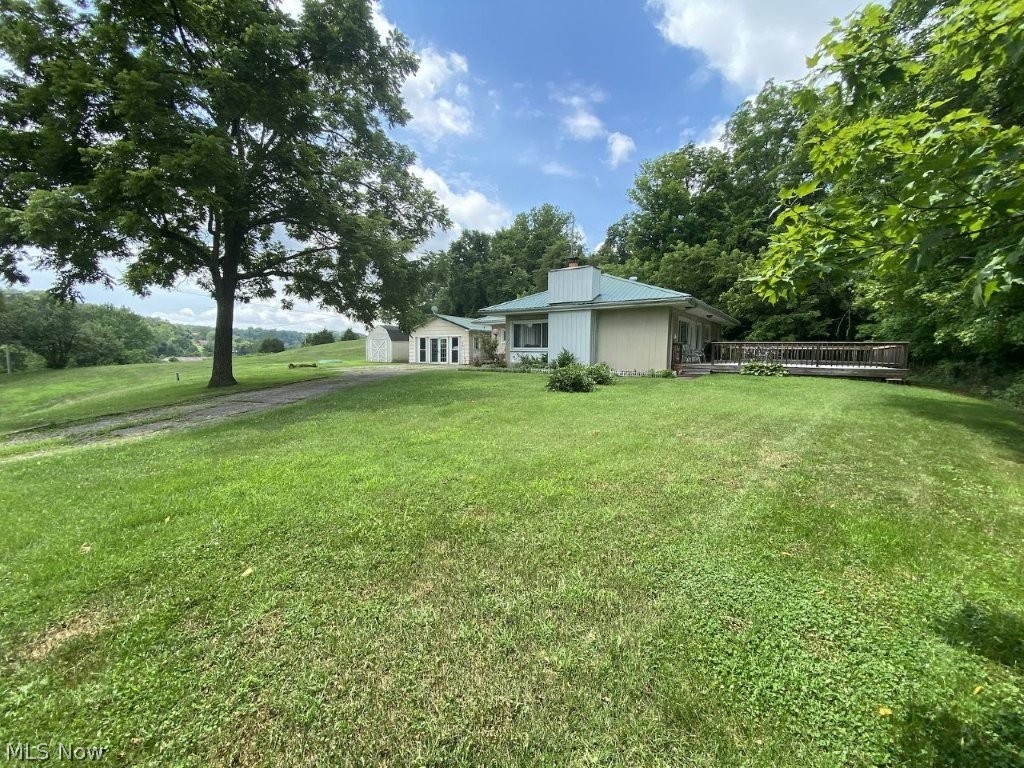 Excellent end of road location. 4.21 Acres with 3 bedroom, 2 bath modified rancher. Interior of home features lots of light, 24x27 back deck and no neighbors. Back of home does not require blinds/drapes unencumbered view of the beautiful Ohio River in distance. Such a great place to relax and entertain guests! This 4.21 Acres is nice land to divide for building lot(s) private from home. Open land bordered by trees. Home features spacious living room13x28, with wood burning fireplace, hardwood floors. Dining room with large built in china cabinet, hardwood floors. Gallery style kitchen offers abundant cabinetry, electric stove. Master bedroom with master bath, 2 additional bedrooms with guest bathroom. This home features easy traffic flow and walk around interior access. Nicely landscaped, garden area. Detached garage is currently used for home business, plywood covers concrete floor which can remain for home business, workshop, hobbies, etc., or removed for vehicle garage use. 10 X 16 storage building. Perfect home location for anyone wanting extra acreage for privacy and excellent for child’s play or pets. Enjoy country living at its best yet convenient to Ravenswood for shopping, dining, Ohio River boating, fishing. Must see to appreciate.