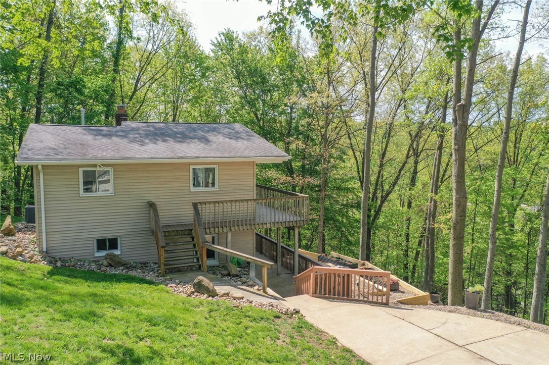 Looking for stunning sunsets from your own deck, enchanting privacy and lake life living ---You Found It!!
Welcome to 195 Oneida Trail, Malvern. Located in the private community of Lake Mohawk, this home includes three lots for a total of 1.38 acres. Beautifully updated home with vaulted, beamed ceilings and so many major upgrades done in the last 4 years.  Move In Ready!  Main level boasts the perfect oasis with outstanding kitchen, newer black stainless steel appliances, granite counters, new hardwood cabinetry and new windows.  Main bath is all new with tile surround, Provia frosted vinyl window, soaking tub and shower. Three sets of sliding glass doors on main floor, which brings in abundance of natural sunlight, leads to the upper deck made with Timbertech composite decking. Lower walk-out level is completely finished and includes family room with stone fireplace with a gas log insert. The laundry/utility room has newer cabinets with Cambria quartz counters. A mini kitchen, second full bath and third bedroom round out the lower level. Other improvements: Lennox gas furnace and AC system, 200 amp panel and service drop, gas line, whole house water filter system, retaining wall and rock landscaping. Seller to retain gas, oil, mineral rights. Lake Mohawk is a private lake in Ohio with a community of boat/lake enthusiasts. It has a 500-acre lake for boating (unlimited horsepower), swimming, beaches, fishing, kayaking, tennis and pickleball courts, clubhouse and baseball field.  Separate membership available for the golf course. Convenient to Akron, Cleveland and Pittsburgh areas.