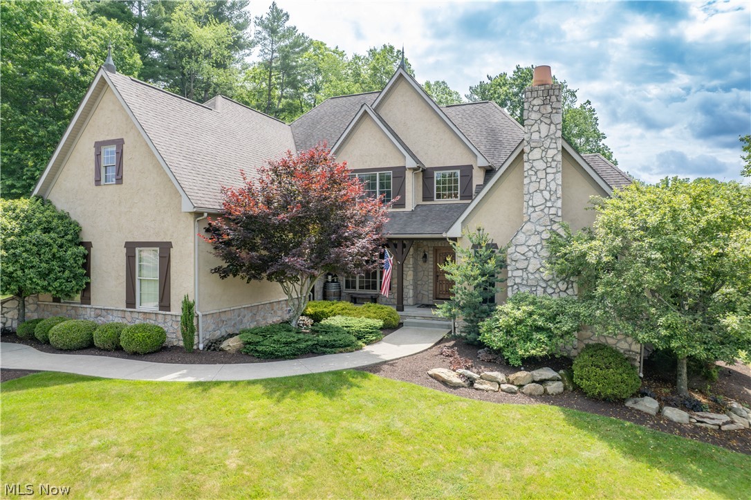 Exceptional Wentworth Homes-built estate offering refined craftsmanship, beautiful updates, and resort-style outdoor living in a desirable neighborhood setting. The stone and stucco exterior, lush landscaping, and covered front porch create an impressive first impression. Inside, a dramatic two-story foyer, hardwood floors, exposed wood beams, balconies, pillars, tray ceilings, built-ins, and rich architectural details carry throughout the home. The main level offers elegant formal living and dining spaces, a private office with fireplace, and a stunning kitchen with Mullet cabinetry, granite countertops, stone backsplash, oversized island, stainless steel appliances, dual wall ovens, pantry, and breakfast nook. The kitchen opens to a vaulted family room/sunroom with exposed beams, fireplace, and beautiful natural light. The first-floor primary suite provides a private retreat with deck access, vaulted morning room, luxurious bath, and spacious walk-in closet. A laundry room, mudroom, powder room, and wine bar complete the main level. Upstairs features a loft and three spacious bedrooms, each with its own full bathroom, walk-in closet and private balconies. The finished walkout lower level is designed for entertaining with a theater room with equipment included, family room, dining area, built-in bar, gym with equipment included, full bath, central vac, and abundant storage. Outdoor living is exceptional with a Trex deck, covered patio, inground saltwater pool with app-controlled equipment, fountains, firepit area, spacious yard, rock path to the creek, and neighborhood walking path. The garage is equally impressive with Nature Stone flooring, painted walls, new openers, and raised tracks. With impressive indoor and outdoor spaces, thoughtful upgrades, and a setting designed for both everyday living and entertaining, this is a truly special home ready for the next owner!