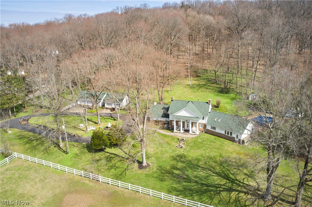Attention Equestrians! This iconic horse property offers a rare opportunity to own 10 picturesque acres in Bath Township. From the moment you arrive at 535 Crystal Lake Road, you’ll recognize the setting: rolling pastures, a striking red barn, & horses grazing against a backdrop of mature trees. The land is thoughtfully arranged with open pasture in front & a serene wooded retreat behind. The impressive 6+ stall barn spans approximately 5,700 sq ft, providing ample space for horses, equipment, and storage.  The colonial home offers 6 BDs, including a first-floor primary suite addition. The formal living room features a fireplace & built-in corner cabinet, while the dining room across the foyer includes additional built-ins. The kitchen offers abundant counter space, storage, & a dining area with a picture window overlooking the rear grounds.  Just off the kitchen, step down to a spacious family room with a custom stone wall, bar area, and rear staircase to the second floor. A rear sitting room provides access to both the pool and first-floor laundry. The primary suite includes an oversized bath with soaking tub beneath a stained-glass window, along with dual walk-in closets. Upstairs are 3 bedrooms and 2 full baths, plus 2 3rd-floor bedrooms, for a total of 6. A bonus room above the family room adds additional second-floor living space.  The home retains much of its original character, offering an opportunity for updates and personalization, particularly in the upper levels and lower level. The basement offers a rec room with FP, ready for future improvement, plus additional storage.  Outside, enjoy the beautifully maintained grounds and in-ground pool—ideal for relaxing after time at the barn. Five garage spaces across two detached garages provide excellent flexibility.  A property combining location, acreage, and equestrian amenities like this is rare, with the added potential to make the home your own over time. Schedule your private showing today.