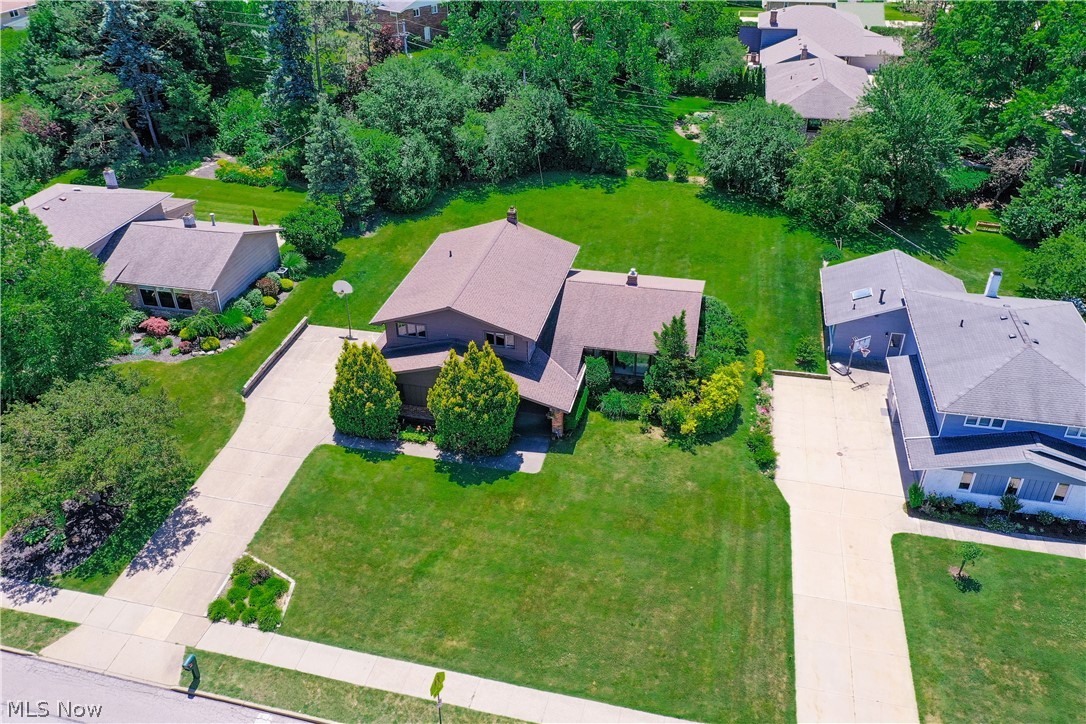 Welcome to this beautiful home filled with country french charm! As you enter through the front door, your eye is immediately drawn to the stunning chandelier and dramatic vaulted ceilings in the formal living room. Just a few steps up, the living room overlooks the front yard through three large floor-to-ceiling windows and flows seamlessly into the formal dining room, creating an ideal layout for entertaining. At the rear of the home, the spacious eat-in kitchen connects to the inviting family room, complete with a bar, stone fireplace, built-in cabinetry, and access to the back patio. Outside, the expansive backyard offers ample space for outdoor activities, while the patio is ready for cookouts with an included natural gas grill. Back inside, you'll find a convenient first-floor laundry room and powder room for guests. Upstairs, the primary suite features three closets and an en-suite bath with a large walk-in shower. Three additional bedrooms and a generously sized guest bath complete this level. The lower level offers a rec room/bonus room, along with plenty of storage space. All of this is just a stone's throw from the Beachwood pool, tennis courts, and playground across the street, with schools, shopping, dining, and entertainment only minutes away.
