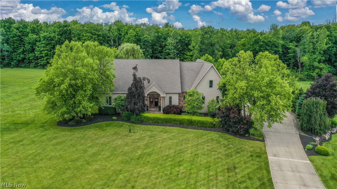 Move right into luxury living in the highly desirable Olde Taylor Woods community. Nestled on more than 3 private acres, this custom home has been thoughtfully updated and offers an exceptional blend of elegance, comfort, and functionality. The redesigned main level features a spacious pantry, full bath, and convenient laundry room. At the heart of the home is a stunning kitchen with granite countertops, travertine backsplash, and abundant cabinetry and workspace. The sunken family room is a true showpiece, boasting soaring vaulted ceilings, exposed beams, skylights, a propane fireplace, and an abundance of natural light. New flooring throughout the lower level adds a fresh, modern feel. The first-floor owner's suite is a private retreat with a large walk-in closet, double granite vanity, makeup station, and relaxing soaker tub. Two additional bedrooms share a Jack-and-Jill bath. Upstairs, a loft-inspired living area creates an open and airy atmosphere with clear railings, bamboo hardwood flooring, vaulted ceilings, and skylights. This level also includes two spacious bedrooms with walk-in closets and an additional full bath. Step outside to a covered deck featuring a wood-burning fireplace and peaceful views of the wooded backyard. The expansive basement offers endless possibilities for storage, recreation, or future finishing. Car enthusiasts and hobbyists will appreciate the heated 6-car garage with three bay doors. Generac 26KW backup generator. With high-end finishes, abundant living space, and a move-in ready design, this one-of-a-kind property offers the luxury lifestyle you've been searching for.