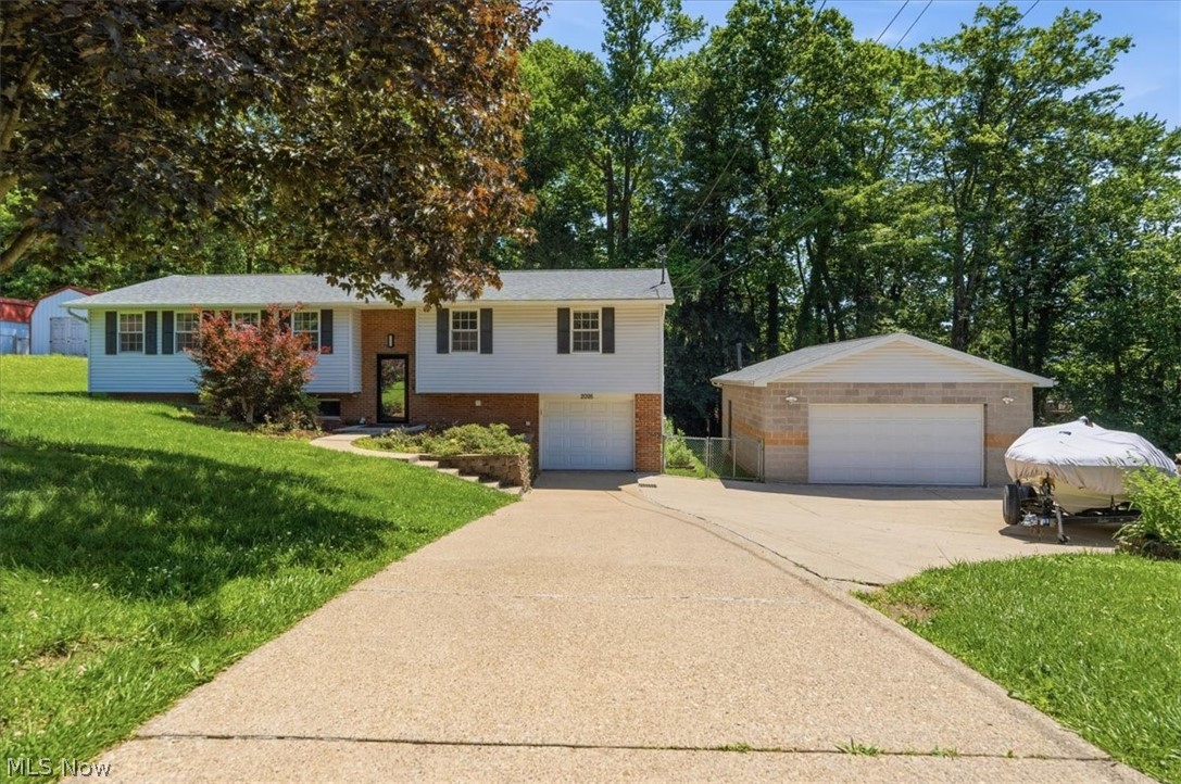 Spacious bi-level home situated on a double lot, offering plenty of room both inside and out! The open-concept kitchen and dining area feature a beautifully renovated kitchen with granite countertops, solid hickory cabinetry, stainless steel appliance package, and new LVP flooring. A large living room provides the perfect space for relaxing or entertaining.  The main level includes three bedrooms, including a primary suite with a private ensuite bath. Both bathrooms have been tastefully renovated with modern finishes.  Step outside to enjoy the brand-new deck, patio area, and fenced backyard, ideal for outdoor gatherings, pets, or play.  Car enthusiasts, hobbyists, and mechanics will appreciate the attached one-car garage plus the impressive 30' x 23' detached garage equipped with heat, air conditioning, water service, and a floor drain. A car lift is also available and negotiable with the sale.  This well-maintained property combines updated living spaces with exceptional garage and outdoor amenities. Don't miss this unique opportunity!  Please note; square footage, room sizes, lot size are approximate.