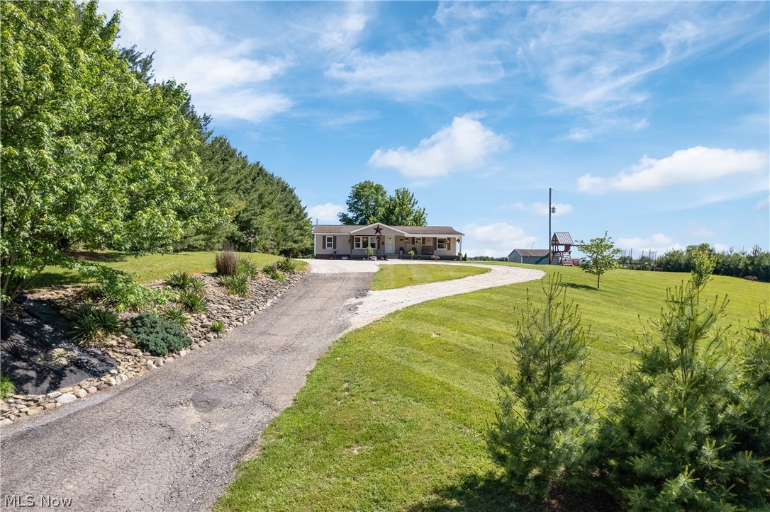 Picture-Perfect Country-Setting! If you're looking for that beautiful rural property with views and easy to maintain, come check this one out. 3-acre tract that is easily mowed with gentle slopes, 2-story 2-stall horse barn, pasture for horses or livestock, good 32x40 garage with 2-overhead doors, lots of newly installed concrete sidewalk and covered patio area, a circular driveway, landscaping, etc. The 1996 3-bedroom, 2-bath single-story home has been updated with new kitchen, laminate and vinyl floor coverings, and much more. Mornings or evenings are enjoyable on the large, covered front porch. Plenty of birds and wildlife to watch here. Tastefully landscaped with flowers, trees and fruit trees as well. Room for a garden or 4-H projects. No zoning. Call to schedule your private viewing today! No Sunday Showings.
