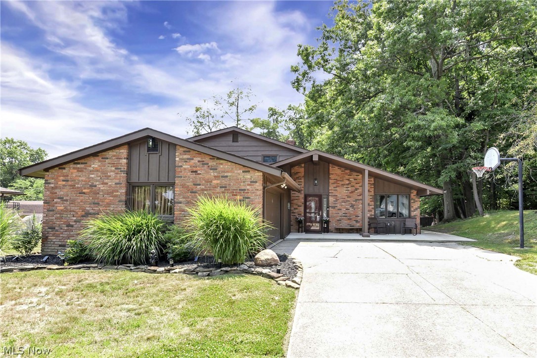 Classic Mid-Century Charm Meets Elevated Modern Living In This Beautifully Updated Split-Level Home. Perfectly Blending Architectural Lines With Organic Materials Bringing A Sense Of Peace & Serenity. The Exposed Wood -Beam Vaulted Ceilings, Sprawling Open Concept Layout, Gorgeous Chef Kitchen & Dining Room Showcasing Large Patio Doors To The Backyard Oasis  Will Draw You & Your Guests In As You Enter Thru The Front Door. The Living Room Wall Features An Earthy Texture Of Stacked Stone Creating An Architectural Contrast With The Warm, Linear Grain Of The Wood Paneling  - Bringing The Outdoors In! Designed For Both Lavish Entertaining & Cozy Gatherings, This Gourmet Kitchen Is Anchored By An Expansive Granite & Stacked Stone Center Island With Pendant Lighting. Stainless Steel Appliances, Lots Of Cabinetry, Counter Space, Storage & Spacious Eat-In Area Nestled Beside A Magnificent Window. The Natural Light Enhances The Rich Textures Of The Room, Making It The Heart Of The Home. Upstairs Features 3 Spacious Bedrooms Boasting Beautiful Hardwood Flooring, Newer Vinyl Windows & Large Closets. Updated Full Bath Offers Dual Sink Vanity With Lots Of Storage. The Lower Level Of The Home Offers A ½ Bath, Laundry Room W/Utility Sink, A Large Family Room With Wood Beams, Built-In Shelving, Beautiful Brick Fireplace With Wood Burning Stove Insert & Patio Doors To Another Backyard Patio. There’s More! Relax & Enjoy The Quiet Restorative Sanctuary Right Off Your Family Room Featuring A Large Jetted Tub! Enjoy Outdoor Living ~ Featuring 2 Concrete Patios & Front Porch, Level Backyard Offering Lots Of Green Space, Fire Pit And The Serenity & Peace Of The Neighboring Trees & Creek. Make This Home Yours Today! Many Updates Including: 2026: Washer & Dryer. 2025: Furnace, Hot Water Tank, Dishwasher & Exterior Painting Of Home. 2020: Concrete For Patio, Walkway On Side Of House & Entire Front Porch. Landscaping ~ Shrubbery & Flower Beds Around Entire House. Newer Vinyl Windows Upstairs.