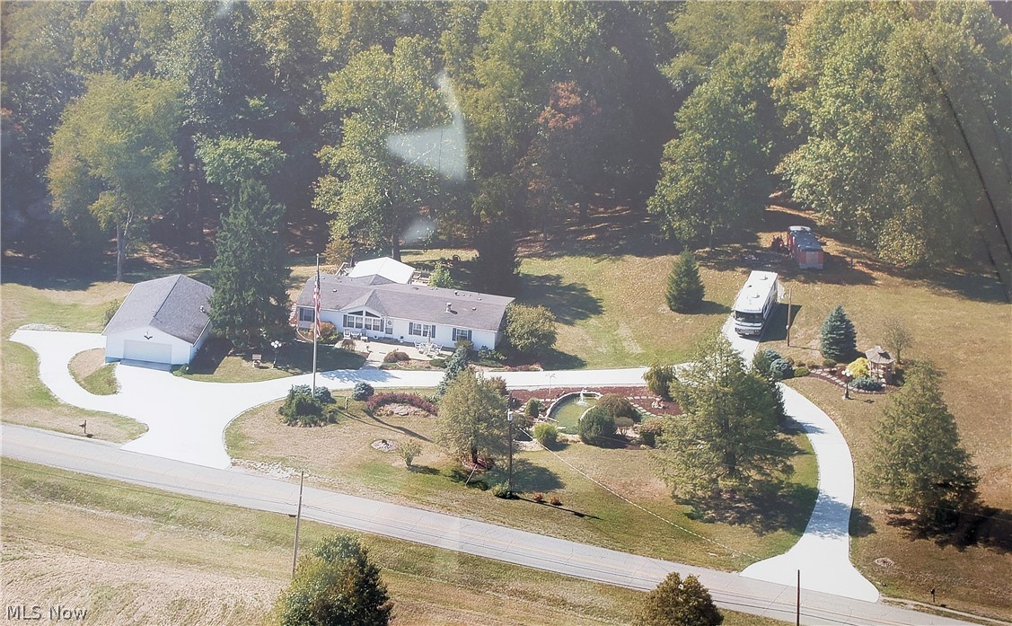 If you are looking for a READY TO MOVE-IN 3 Bedroom 2 Bath home on 3 plus park like manicured acres, just minutes from Belpre. ALL ON ONE FLOOR WITH A 4 CAR GARAGE! HERE IT IS!
You drive in a on a circular driveway surrounded by beautiful landscaping with a flagpole which says Welcome. Open concept with vaulted ceiling and French doors looking to a full season glassed in sunroom. The sunroom has a wraparound deck allowing a spectacular view of a park like setting. Three Bedrooms and Two Bathrooms. The Master Bedroom has a large Master Bath with a walk-in shower, corner tub, and oak cabinetry.
The fully equipped eat-in kitchen has ample cabinet space and a built in desk. The detached 4 car garage is fully insulted, and has heat, water, and tool bench.  THIS IS A MUST SEE!!