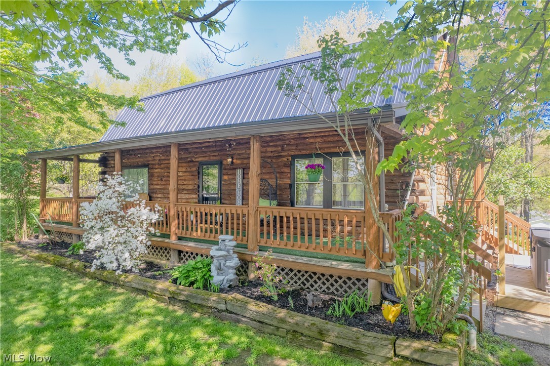 4897 Chestnut Drive is the kind of property buyers wait for -- a true cabin-style retreat tucked on over 2 private acres located in desirable Sherman Wood Estates in Brimfield Township. Set on a hilltop with a long wraparound private driveway, wooded property lines, and peaceful scenery, this move-in ready home blends rustic character with modern updates while offering over 2,600 square feet of living space, a cozy fireplace in the living room, 5 bedrooms and 3 full baths. Inside, you'll find warm, inviting living spaces, exposed beams, a renovated kitchen with updated stainless steel appliances that stay, updated bathrooms, newer LVP flooring throughout, fresh paint, and a flexible layout designed for both everyday living and entertaining. 4 bedrooms are on the upper level and 1 is in the basement, with a full bath located on all 3 levels. The walk-out basement adds incredible versatility with a spacious rec room/flex space, walkout access, and a fifth bedroom perfect for guests, an office or home gym. Enjoy quiet mornings on the inviting and expansive covered front porch, summer days by the 28-foot-above-ground pool with a deck and evenings relaxing on the side deck overlooking the property. An oversized 3-car garage (24x40ft/960sqft) features a tandem-style access with dual overhead doors for added convenience and functionality. Major improvements include newer septic, well pump, water softener system, propane tank (with sensors to alert when fuel is running low), metal roof, electrical panel, basement propane heater, paint and flooring, light fixtures, and much more offering peace of mind for years to come. The property includes a storage shed, chicken coop with fencing and scenic outdoor spaces that make this home feel like a private getaway while remaining conveniently located near KSU, I-76, shopping, and dining. Field LSD. Properties offering this level of privacy, character, and acreage rarely become available!